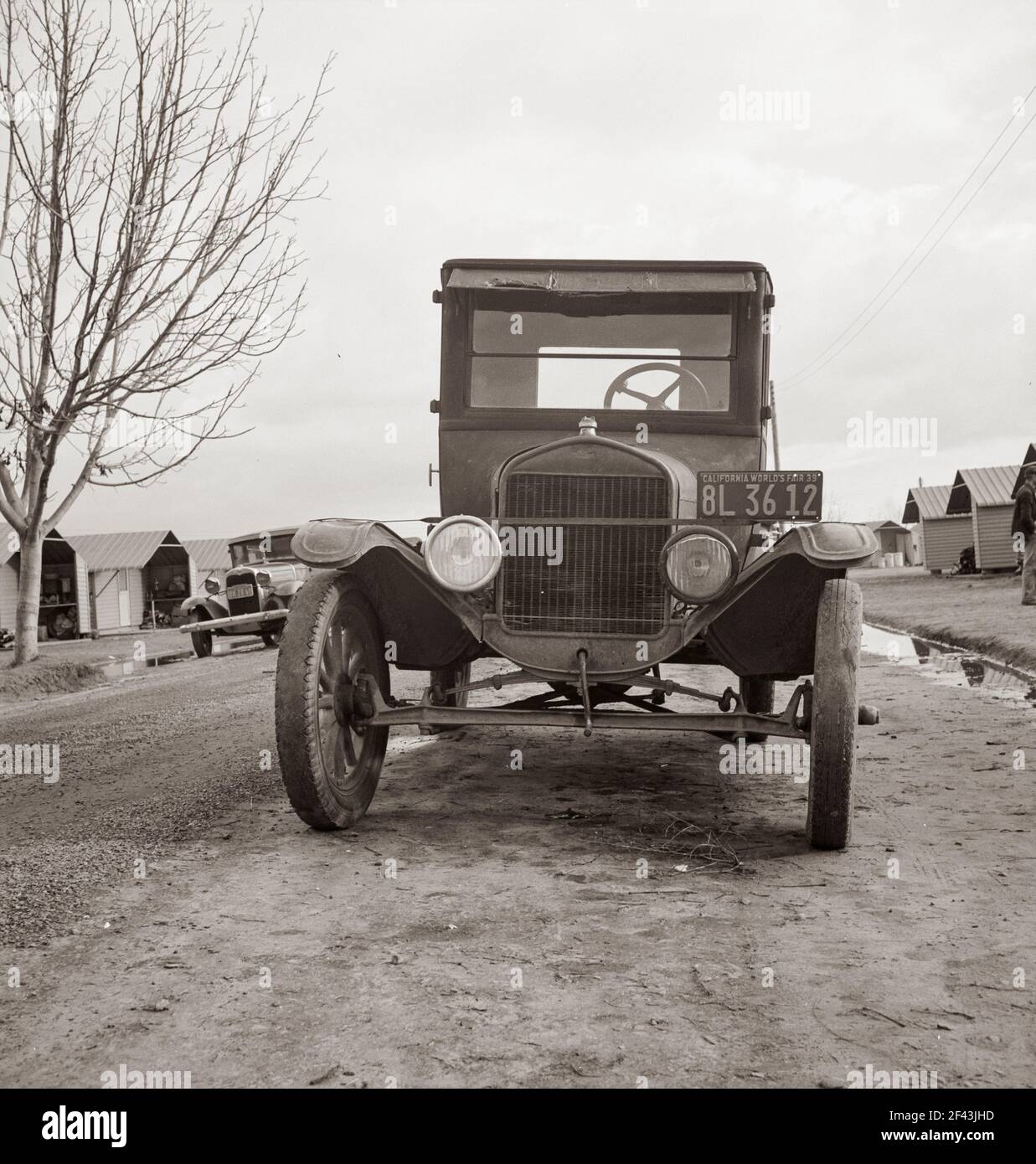 Dans le camp de travail migratoire de l'Administration de la sécurité agricole à Farmersville, en Californie. Les Fords du modèle T transportent encore des migrants. Février 1939. Photo de Dorothea Lange. Banque D'Images