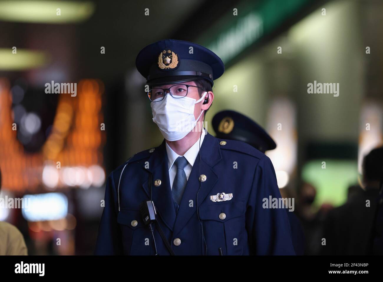 Tokyo, Japon. 18 mars 2021. Un policier japonais portant un masque facial comme mesure préventive contre la propagation de Covid-19 vu en service dans le district de Shibuya la nuit. Le gouvernement va lever l'état d'urgence dans la région de Tokyo le 21 mars 2021. (Photo de Stanislav Kogiku/SOPA Images/Sipa USA) crédit: SIPA USA/Alay Live News Banque D'Images