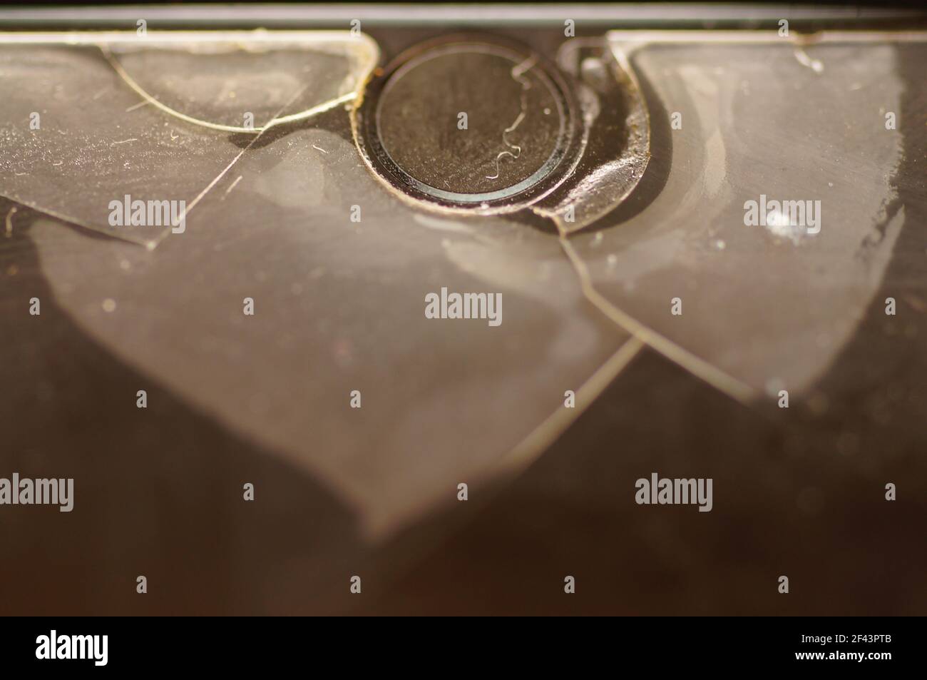 Vitre de protection du smartphone : endommagée, fissurée, usée. Ancienne protection de l'écran. Téléphone sale, noir, usé. Banque D'Images