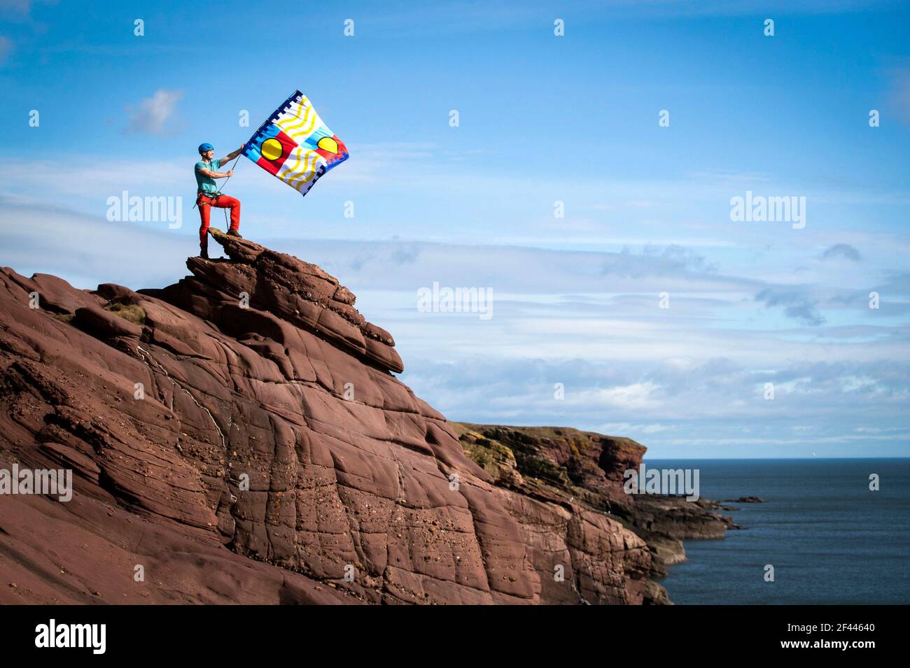 L'aventurier extérieur Kevin Meldrum vole l'un des drapeaux créés pour le projet 701 Flags sur les falaises de Seaton à Arbroath. Date de la photo: Jeudi 18 mars 2021. Banque D'Images