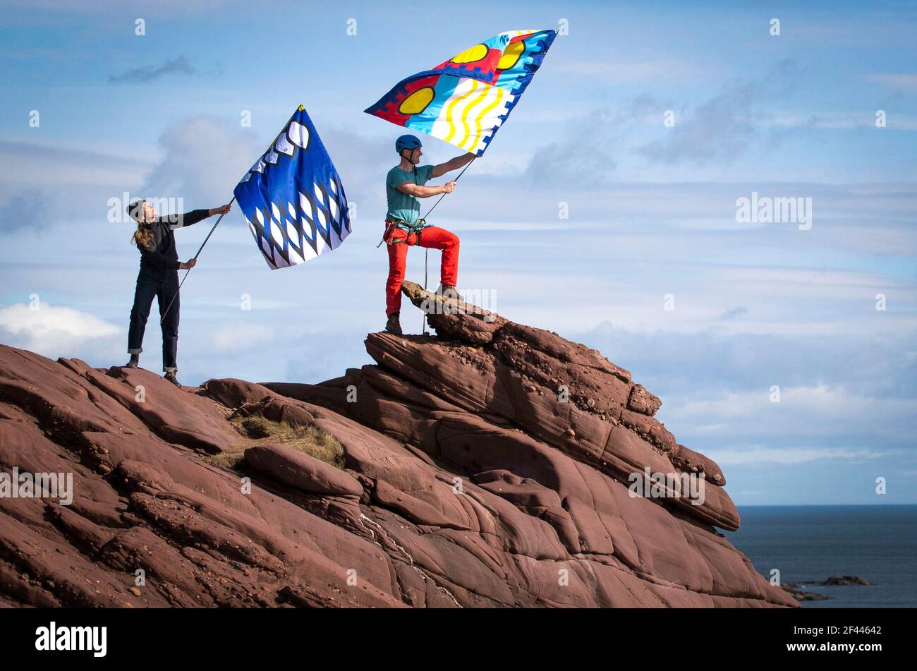 La productrice créative Pippa Martin (à gauche) et l'aventurier extérieur Kevin Meldrum volent certains des drapeaux créés pour le projet 701 Flags sur les falaises de Seaton à Arbroath. Date de la photo: Jeudi 18 mars 2021. Banque D'Images