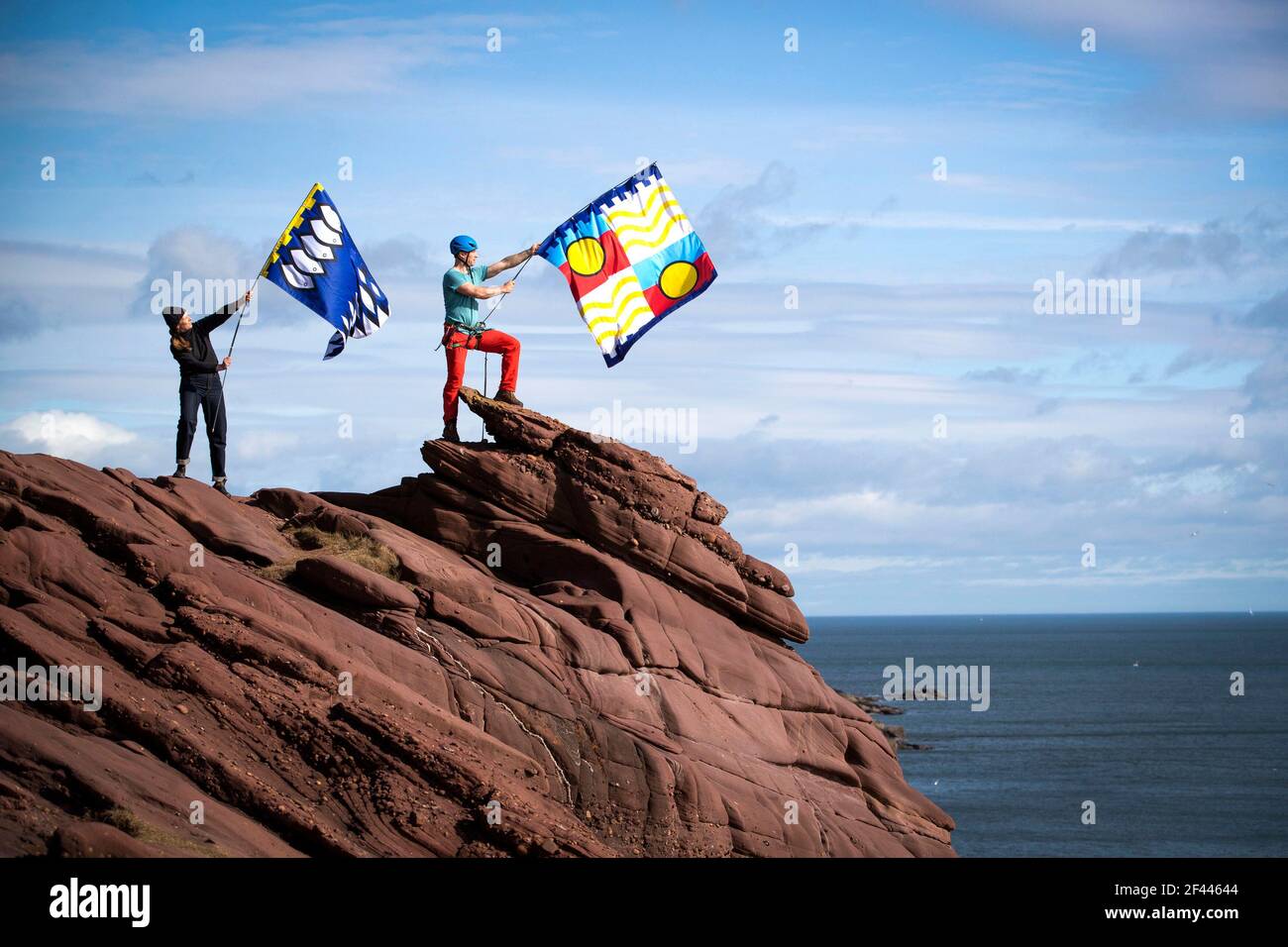 La productrice créative Pippa Martin (à gauche) et l'aventurier extérieur Kevin Meldrum volent certains des drapeaux créés pour le projet 701 Flags sur les falaises de Seaton à Arbroath. Date de la photo: Jeudi 18 mars 2021. Banque D'Images
