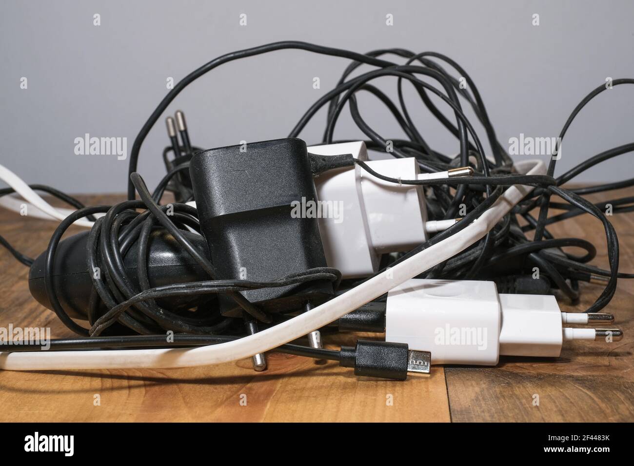 Pile de chargeurs filaires de smartphone usagés, déchets électroniques, outils de dispositifs techniques Banque D'Images