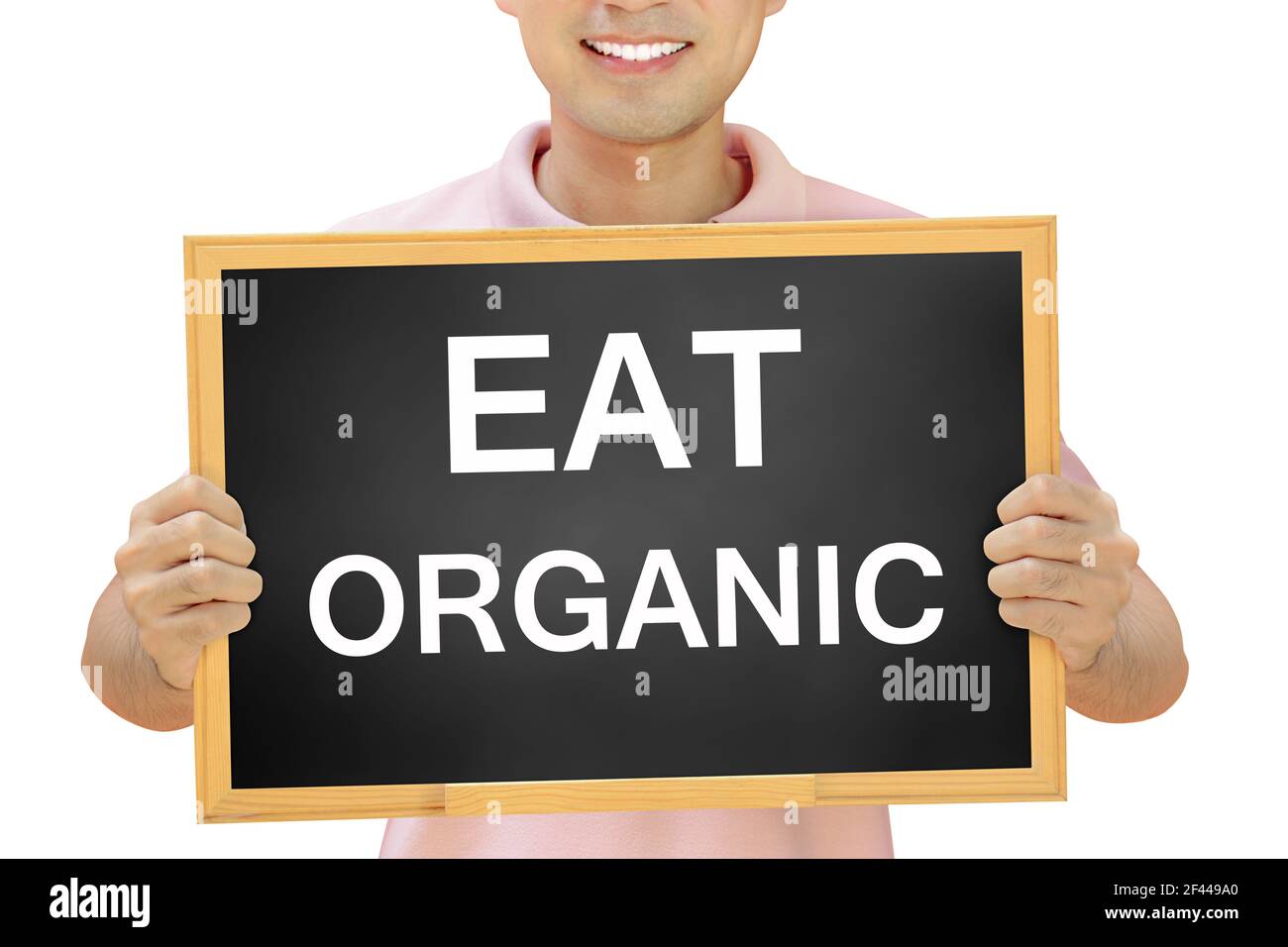 MANGEZ DU texte ORGANIQUE sur le tableau noir tenu par l'homme souriant Banque D'Images