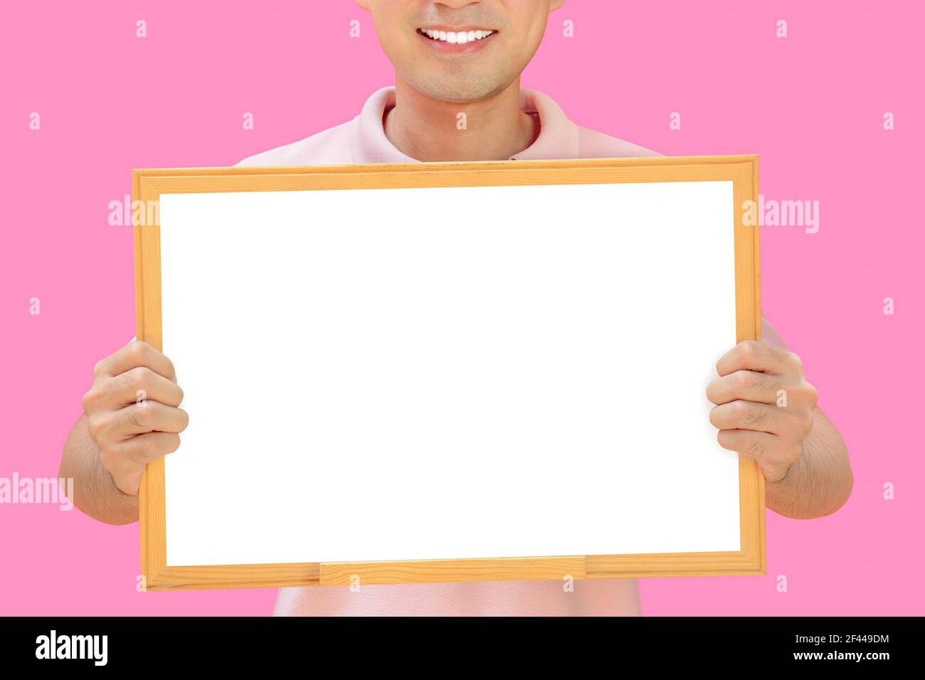 Homme souriant tenant un tableau blanc vide - peut remplir vos textes et être utilisé comme écriteau, avis et tableaux publicitaires, etc Banque D'Images