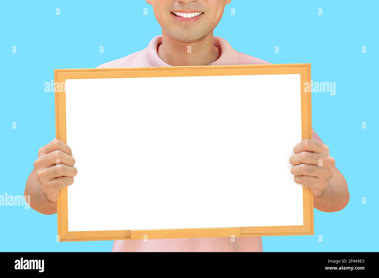 Homme souriant tenant un tableau blanc vide - peut remplir vos textes et être utilisé comme écriteau, avis et tableaux publicitaires, etc Banque D'Images