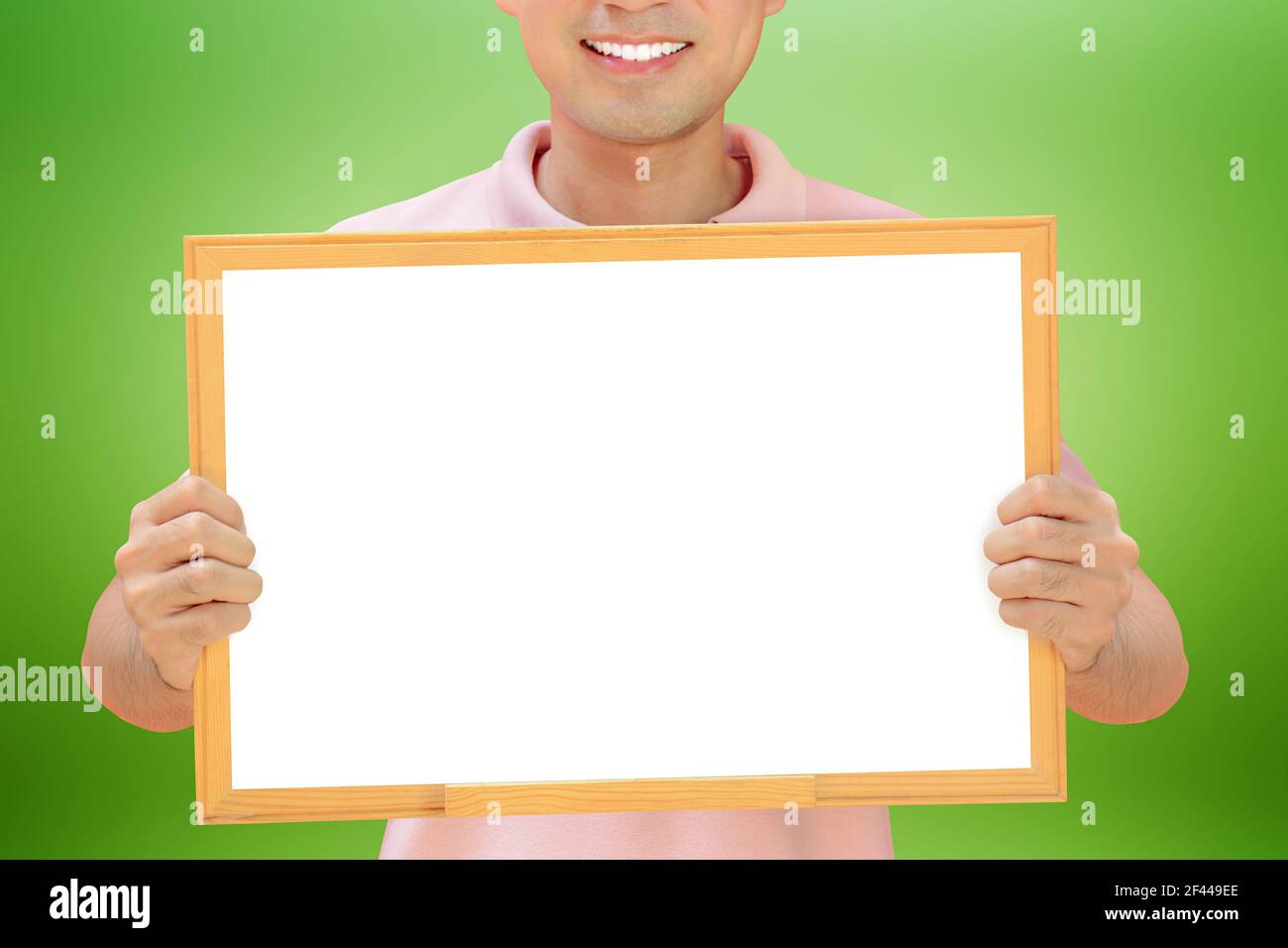Homme souriant tenant un tableau blanc vide - peut remplir vos textes et être utilisé comme écriteau, avis et tableaux publicitaires, etc Banque D'Images