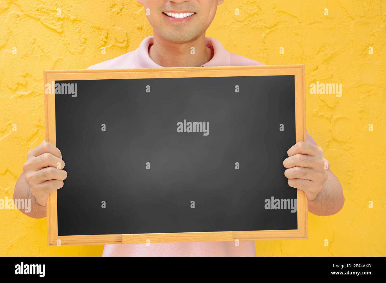 Tableau noir vierge tenu par un homme souriant Banque D'Images