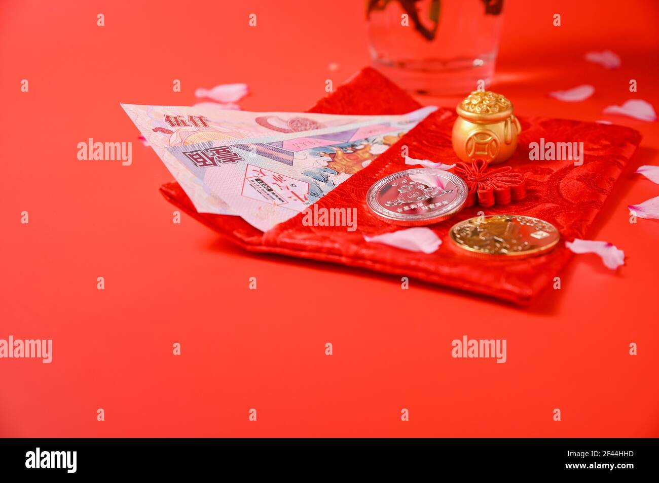 Le nouvel an chinois 2021 est l'année du boeuf, caractères chinois . Déco nouvel an chinois. Lingot d'or et abacus d'or. Pétales d'amande et pièces de monnaie en fleurs sur fond rouge. Copier l'espace Banque D'Images