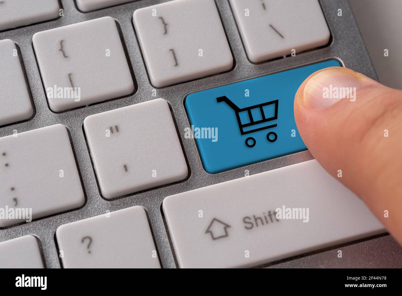 Main mâle appuyant sur le bouton du clavier avec le panier. Achat en ligne. Banque D'Images