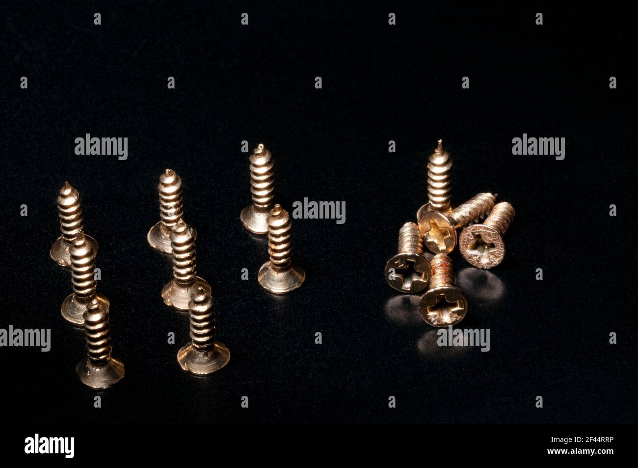 Concept de construction d'équipe avec vis en laiton sur fond noir Banque D'Images
