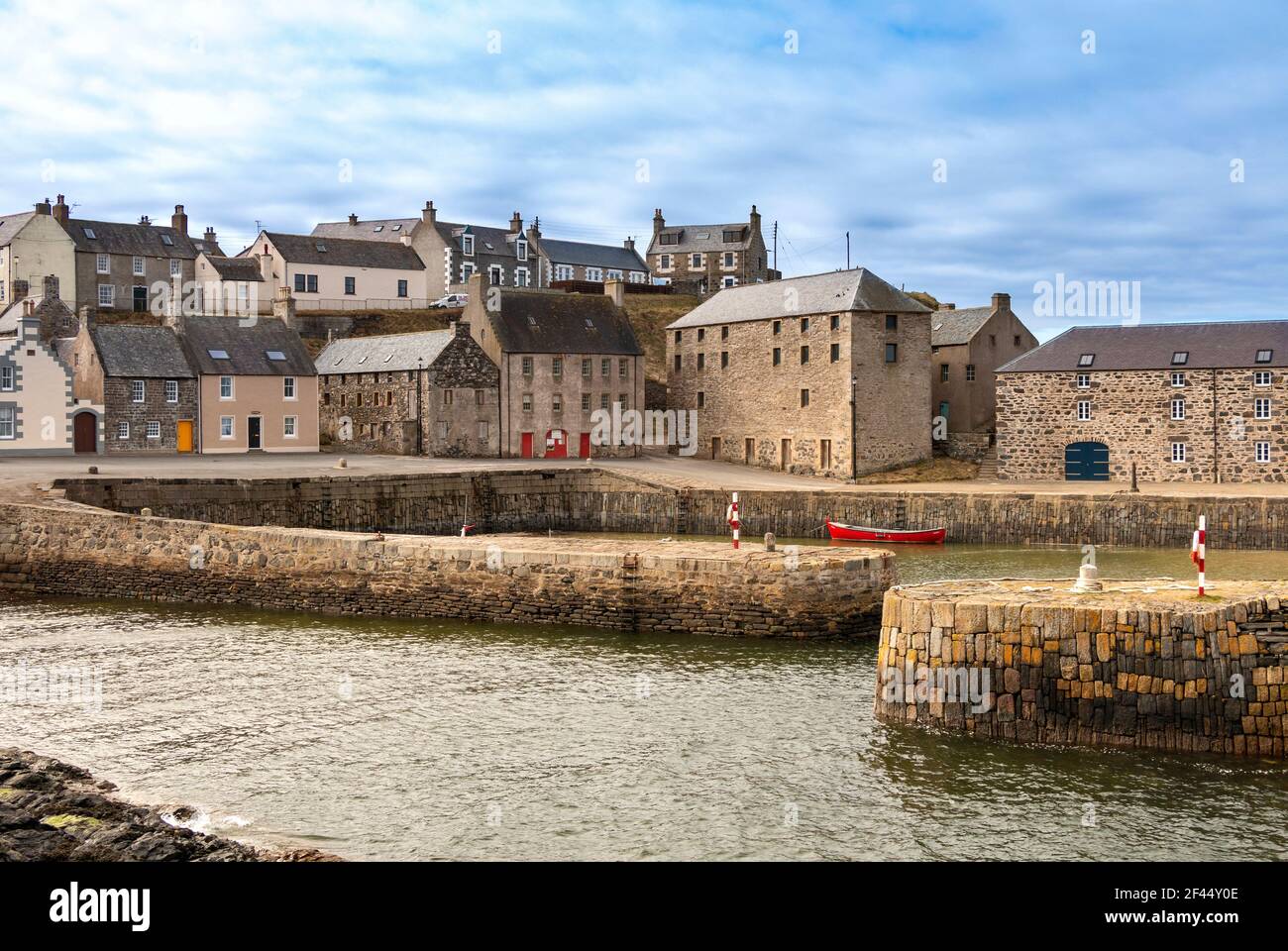 PORTSOY OLD HARBOUR MORAY FIRTH ABERDEENSHIRE SCOTLAND LES VIEILLES MAISONS ET UN BATEAU ROUGE Banque D'Images