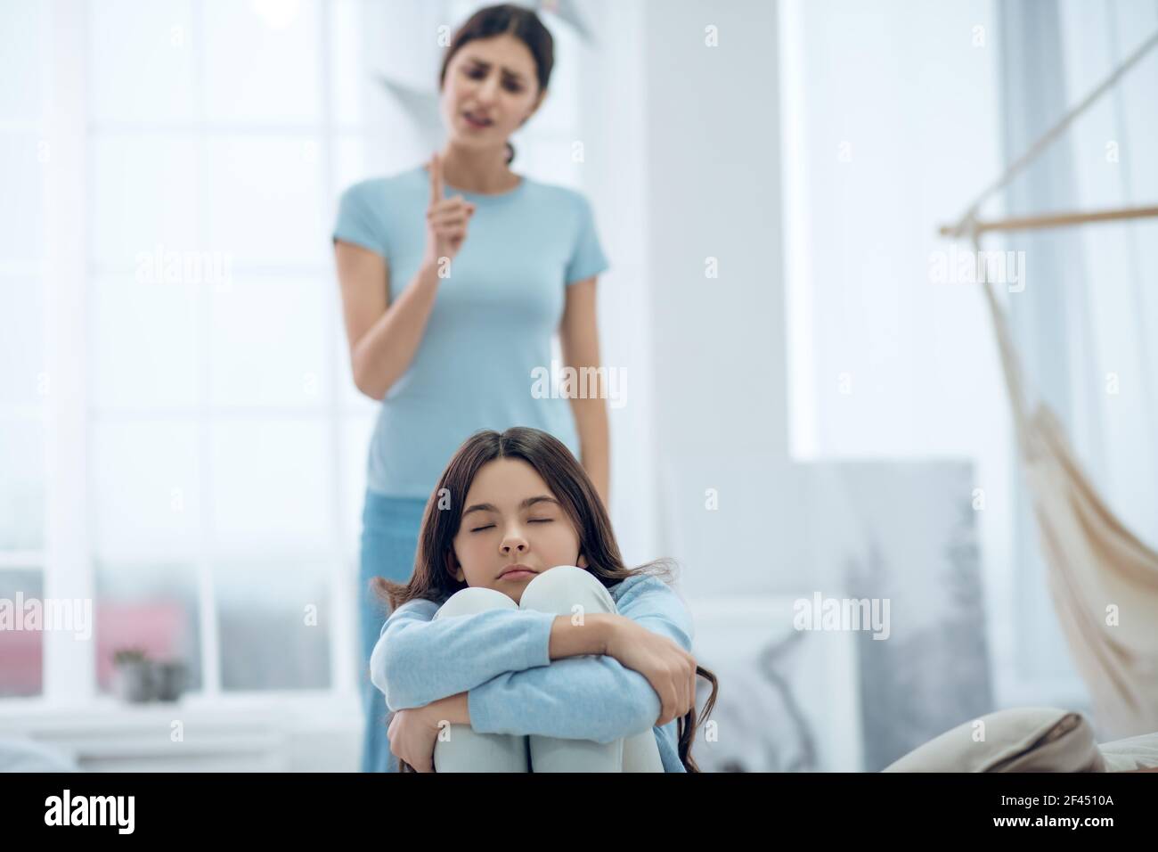 Fille retournée avec les yeux fermés et maman derrière Banque D'Images