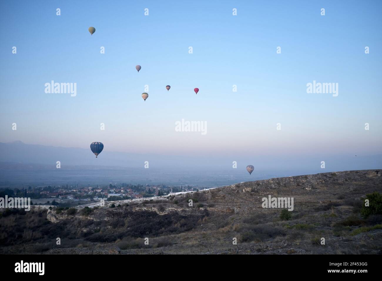 Ballons d'air chaud multicolores volant dans le ciel du lever du soleil. Banque D'Images