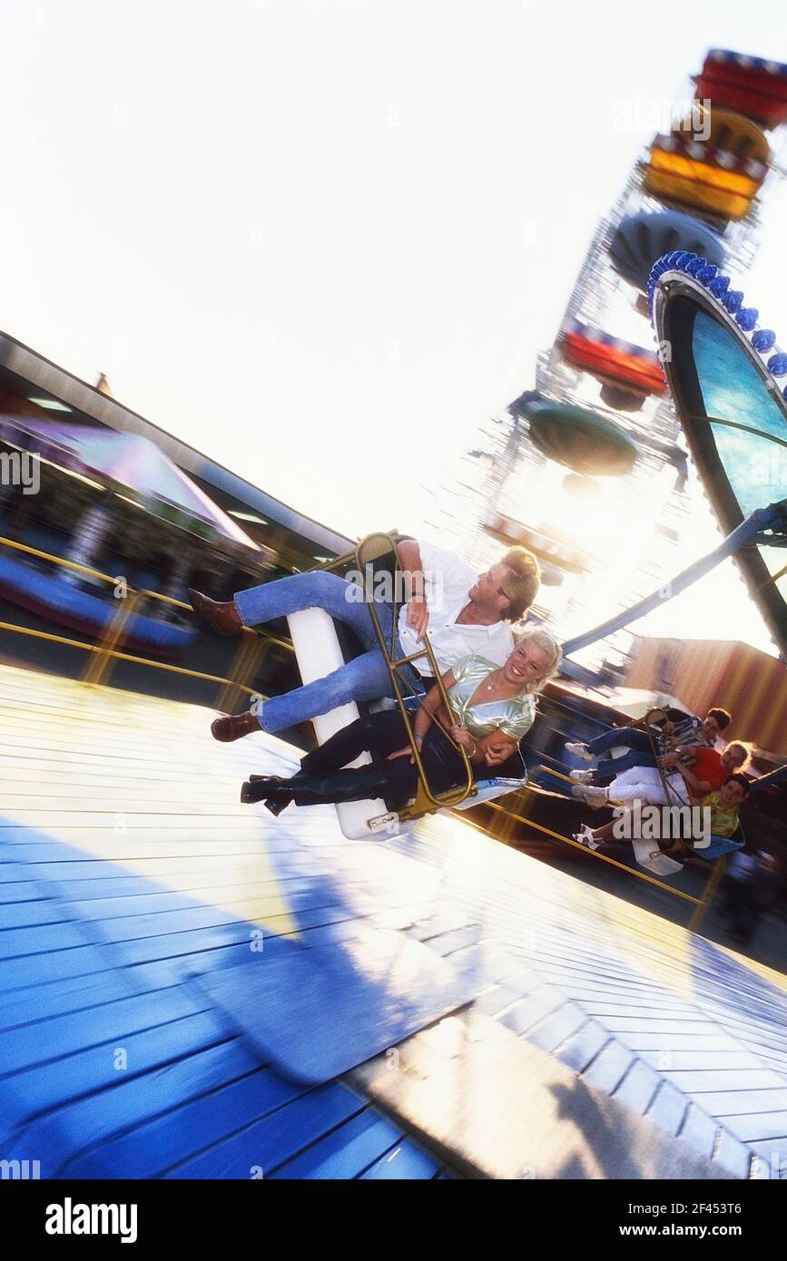 Un jeune couple adulte sur le Parapluie/les parachutistes de levage se font à Bottons Pleasure Beach, Skegness, Lincolnshire. Angleterre Royaume-Uni Banque D'Images