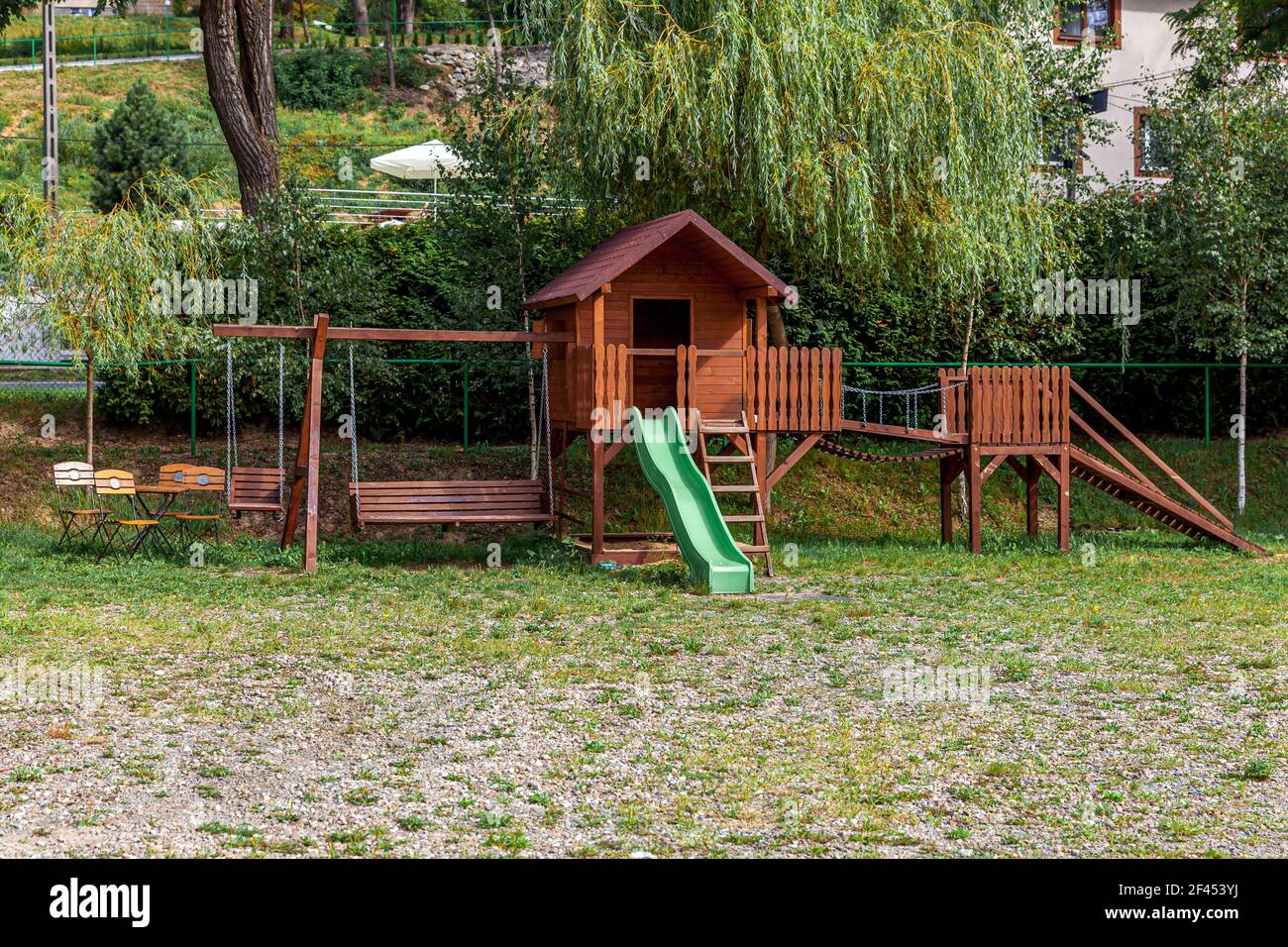 Aire de jeux en bois moderne et vide située sur une cour verte dans le parc public en été. Terrain de jeu amusant pour les enfants. Activités d'exercices urbains pour les enfants o Banque D'Images
