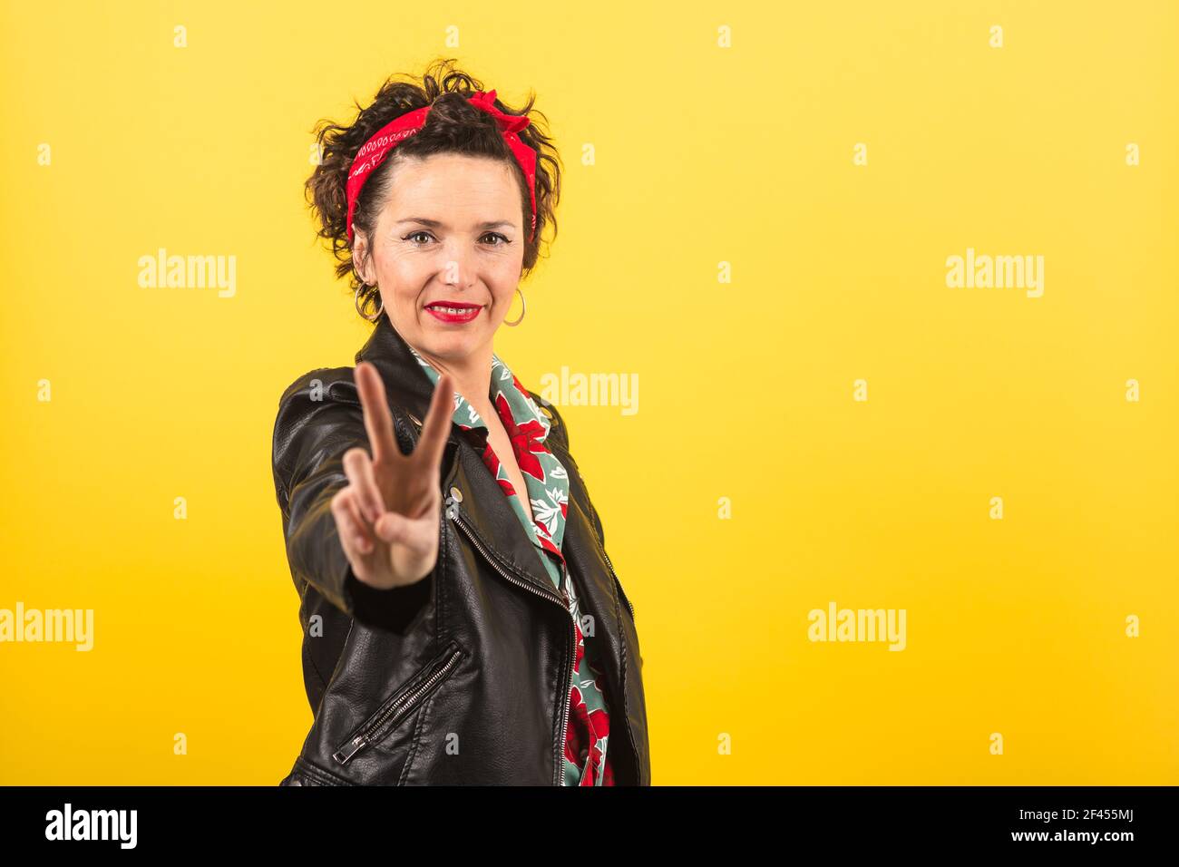 Épinglez la femme montrant le symbole de la victoire avec sa main Banque D'Images