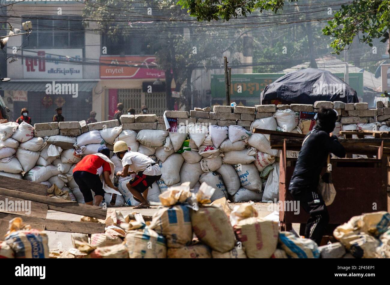 Les manifestants anti-coup d'Etat militaire se cachent derrière une barricade improvisée tout en tenant des cocktails molotov lors d'une manifestation contre le coup d'Etat militaire. La police et les militaires du Myanmar (tatmadow) ont attaqué les manifestants avec des balles en caoutchouc, des munitions réelles, des gaz lacrymogènes et des bombes lacrymogènes en réponse aux manifestants anti-coup d'État militaire de vendredi, tuant plusieurs manifestants et en blessant beaucoup d'autres. Au moins 149 personnes ont été tuées au Myanmar depuis le coup d'État du 1er février, a déclaré un responsable des droits de l'homme de l'ONU. L'armée du Myanmar a détenu le conseiller d'État du Myanmar Aung San Suu Kyi le 01 février 2021 et Banque D'Images