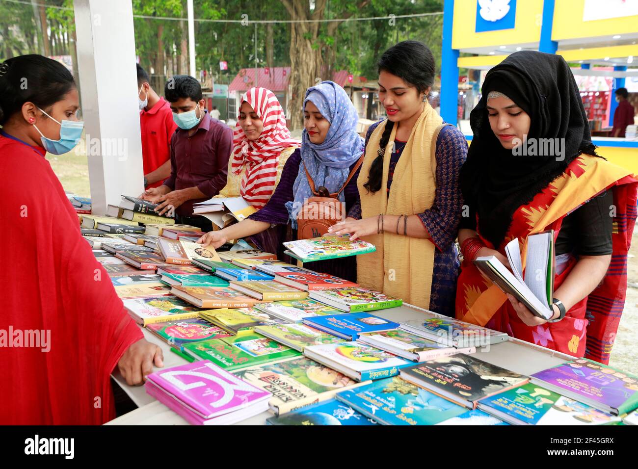 Dhaka, Bangladesh - 18 mars 2021 : les visiteurs parcourent des livres dans un stand de la foire du livre d'Ekushey à Suhrawardy Udyan à Dhaka. La foire, traditionnellement organi Banque D'Images