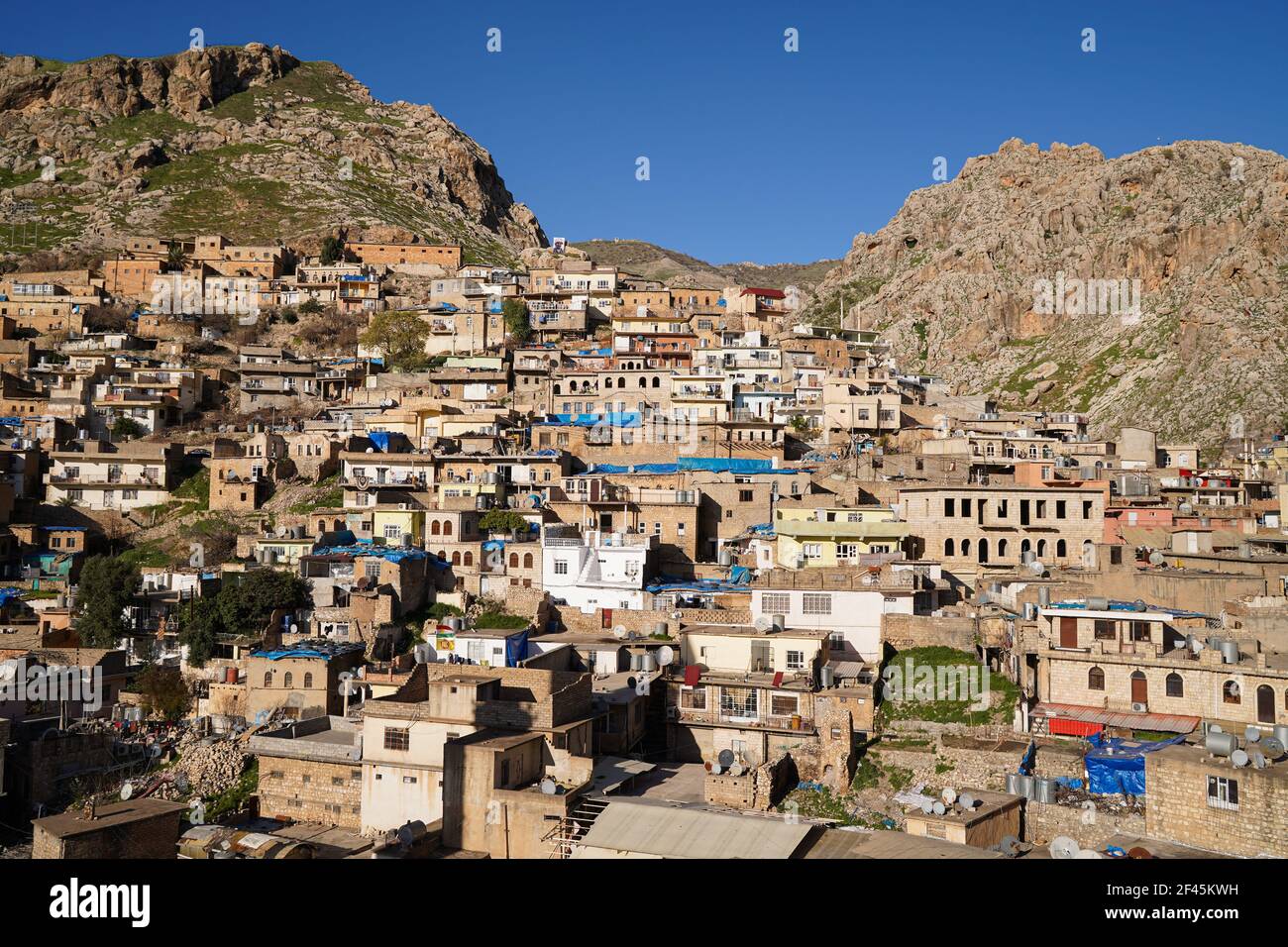 Vue sur les maisons construites sur le flanc de la montagne de la vieille ville d'Akre.la ville d'Akre dans le gouvernorat de Duhok se prépare à célébrer Nowruz (le nouvel an persan ou le nouvel an kurde) en accrochant des drapeaux sur les montagnes. Le nouvel an perse ou le nouvel an kurde est une ancienne tradition zoroastrienne célébrée par les Iraniens et les Kurdes le 20 mars de chaque année et coïncide avec l'équinoxe vernal. Banque D'Images