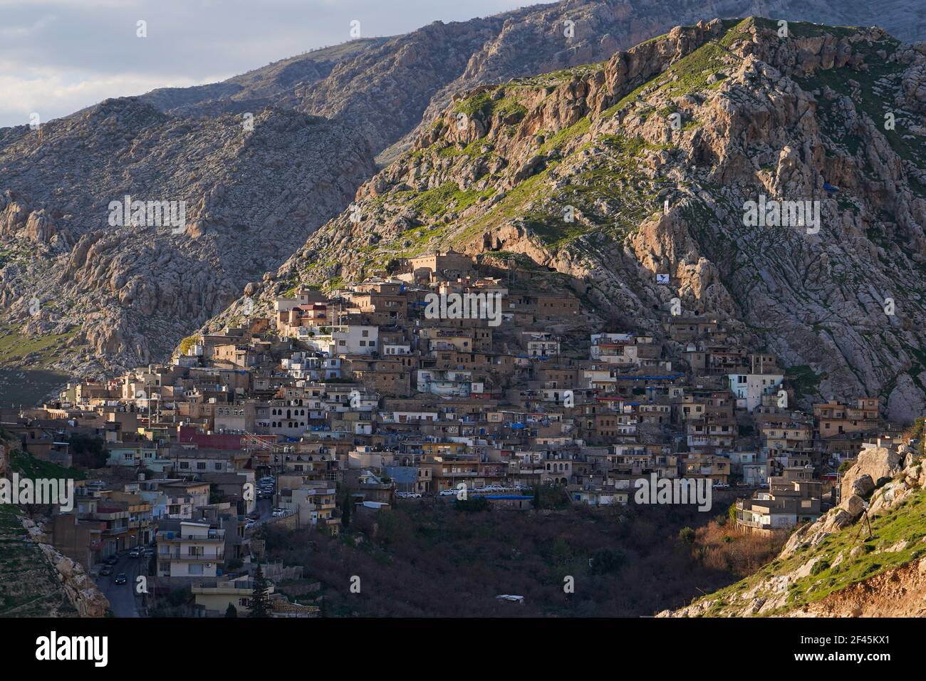 Vue sur les maisons construites sur le flanc de la montagne de la vieille ville d'Akre.la ville d'Akre dans le gouvernorat de Duhok se prépare à célébrer Nowruz (le nouvel an persan ou le nouvel an kurde) en accrochant des drapeaux sur les montagnes. Le nouvel an perse ou le nouvel an kurde est une ancienne tradition zoroastrienne célébrée par les Iraniens et les Kurdes le 20 mars de chaque année et coïncide avec l'équinoxe vernal. Banque D'Images