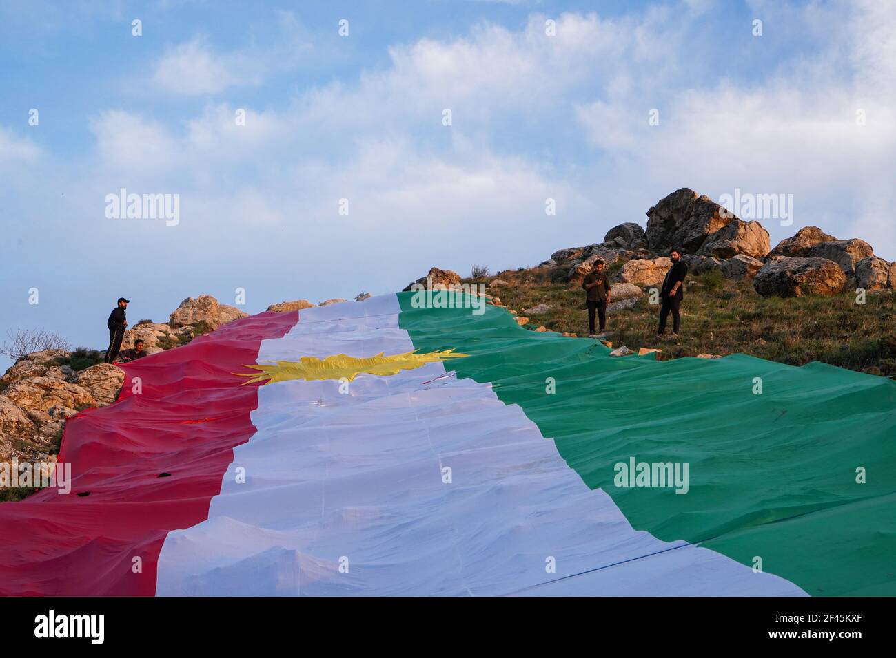 Les Kurdes placent un drapeau du Kurdistan sur l'une des montagnes de la vieille ville d'Akre.la ville d'Akre dans le gouvernorat de Duhok se prépare à célébrer Nowruz (le nouvel an persan ou le nouvel an kurde) en accrochant des drapeaux sur les montagnes. Le nouvel an perse ou le nouvel an kurde est une ancienne tradition zoroastrienne célébrée par les Iraniens et les Kurdes le 20 mars de chaque année et coïncide avec l'équinoxe vernal. Banque D'Images