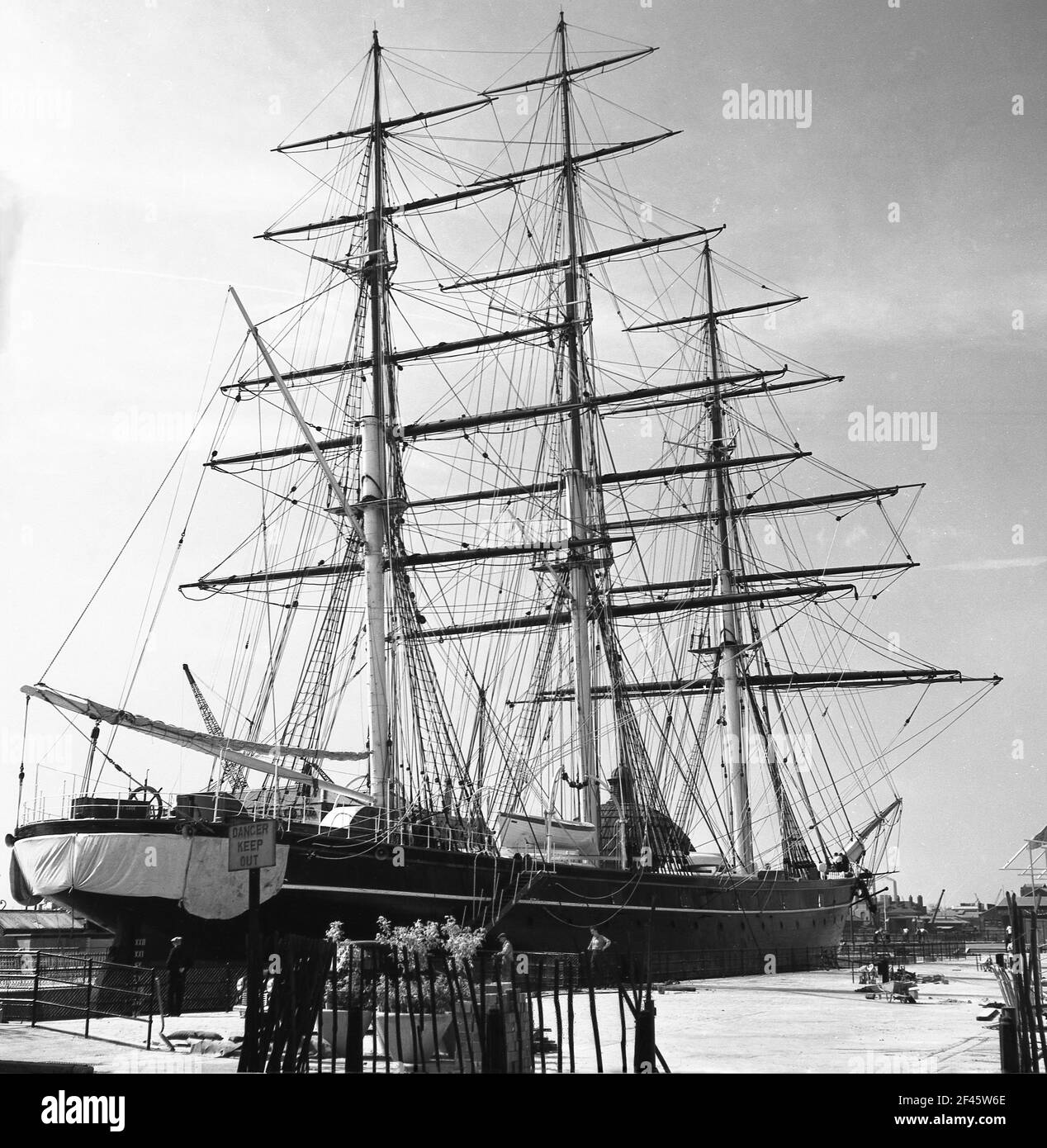 1950s, historique, le célèbre bateau à découper, le Cutty Sark amarré à Greenwich, dans le sud de Londres. À ce moment-là, pas l'attraction de visiteur elle est devenue, car il y a un panneau sur le quai indiquant, 'danger garder dehors". Banque D'Images