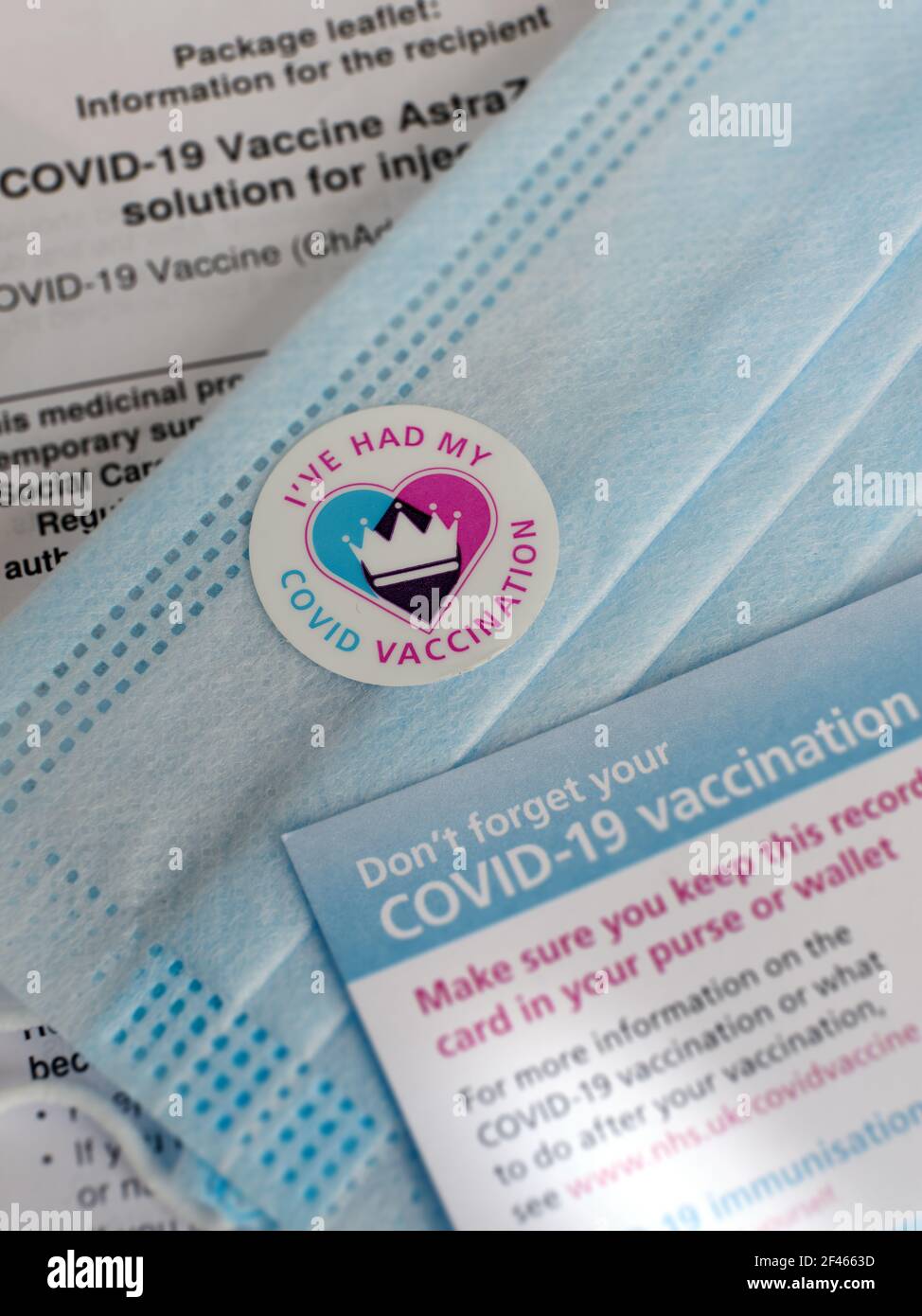 Covid-19 autocollant vaccin / vaccination, masque bleu, fiche de vaccination NHS et fiche d'information sur le vaccin AstraZenica - épreuve de vaccination Banque D'Images Covid-19 autocollant vaccin / vaccination, masque bleu, fiche de vaccination NHS et fiche d'information sur le vaccin AstraZenica - épreuve de vaccination Banque D'Images