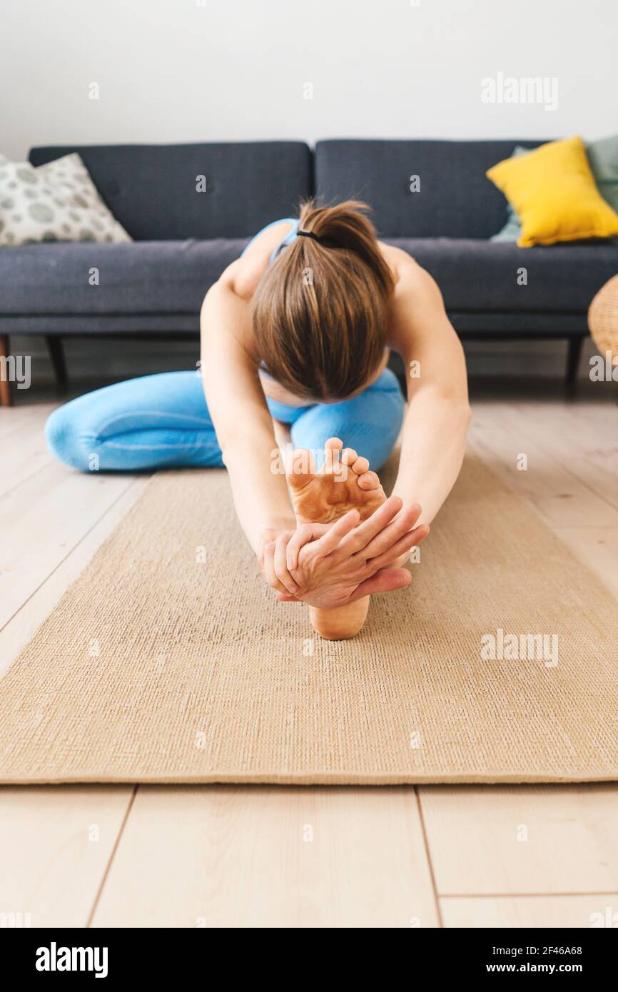 Portrait d'une jeune femme pratiquant le yoga à l'intérieur. Femme pratique janu sirsasana à la maison. Banque D'Images