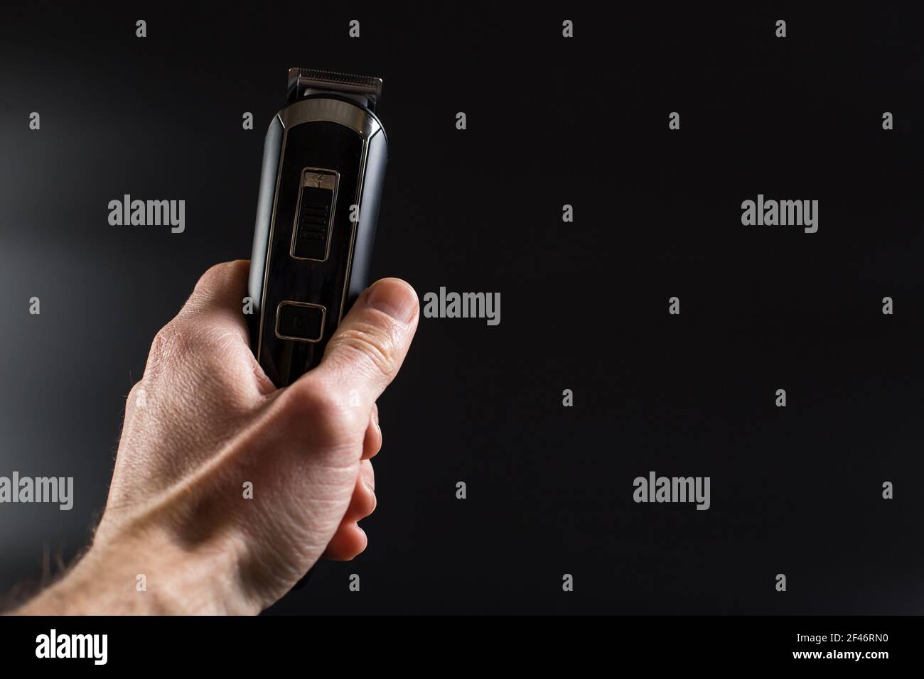 Laser sans fil dans la main de l'homme sur fond noir avec espace de copie. Banque D'Images