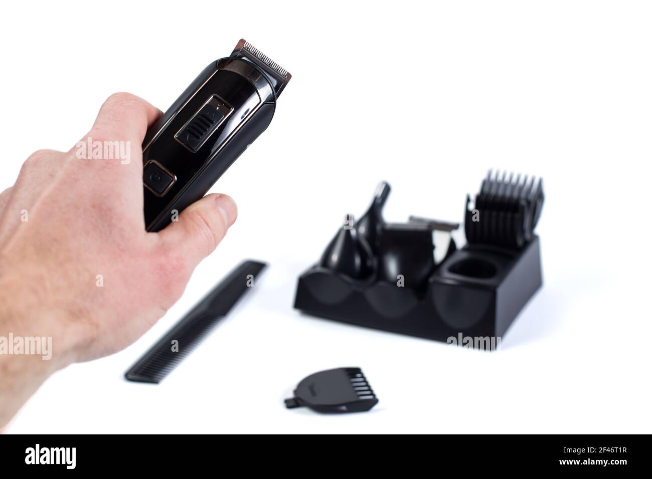 Main de coiffeur tenant le razer sans fil isolé sur un whiet et les accessoires sur l'arrière-plan. Banque D'Images
