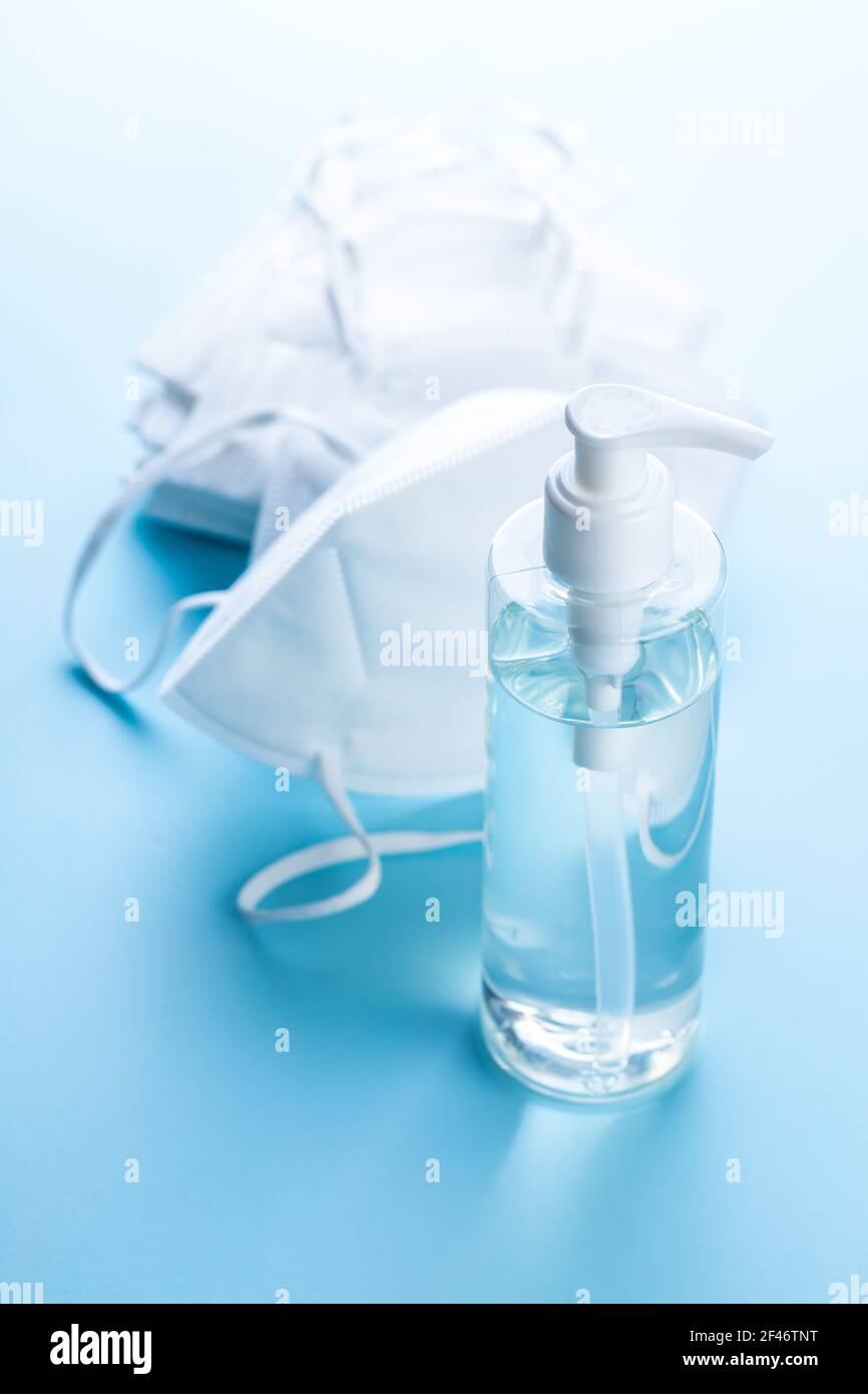 Prévention des coronavirus désinfectant pour les mains et masque respiratoire kn95. Gel désinfectant pour les mains dans le flacon de pompe sur la table bleue. Banque D'Images