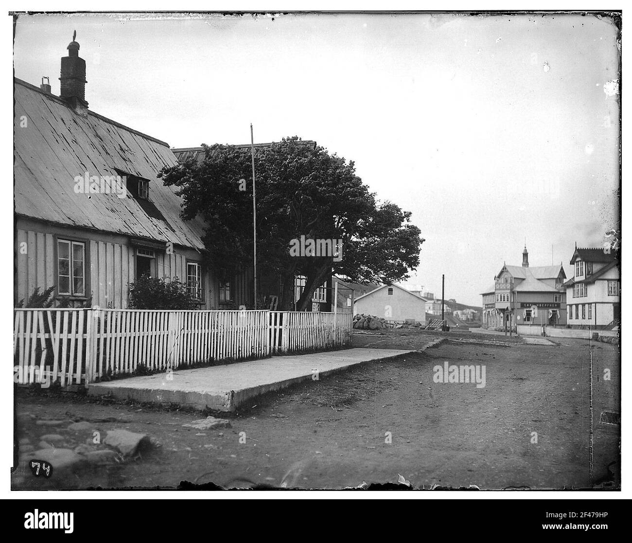 Akureyri (Islande). Maison résidentielle avec cour avant clôturée (dans le seul arbre [Ebersche] de la station). Vue vers l'ouest à travers une route non pavée jusqu'à la pente de l'Eyjafjord Banque D'Images