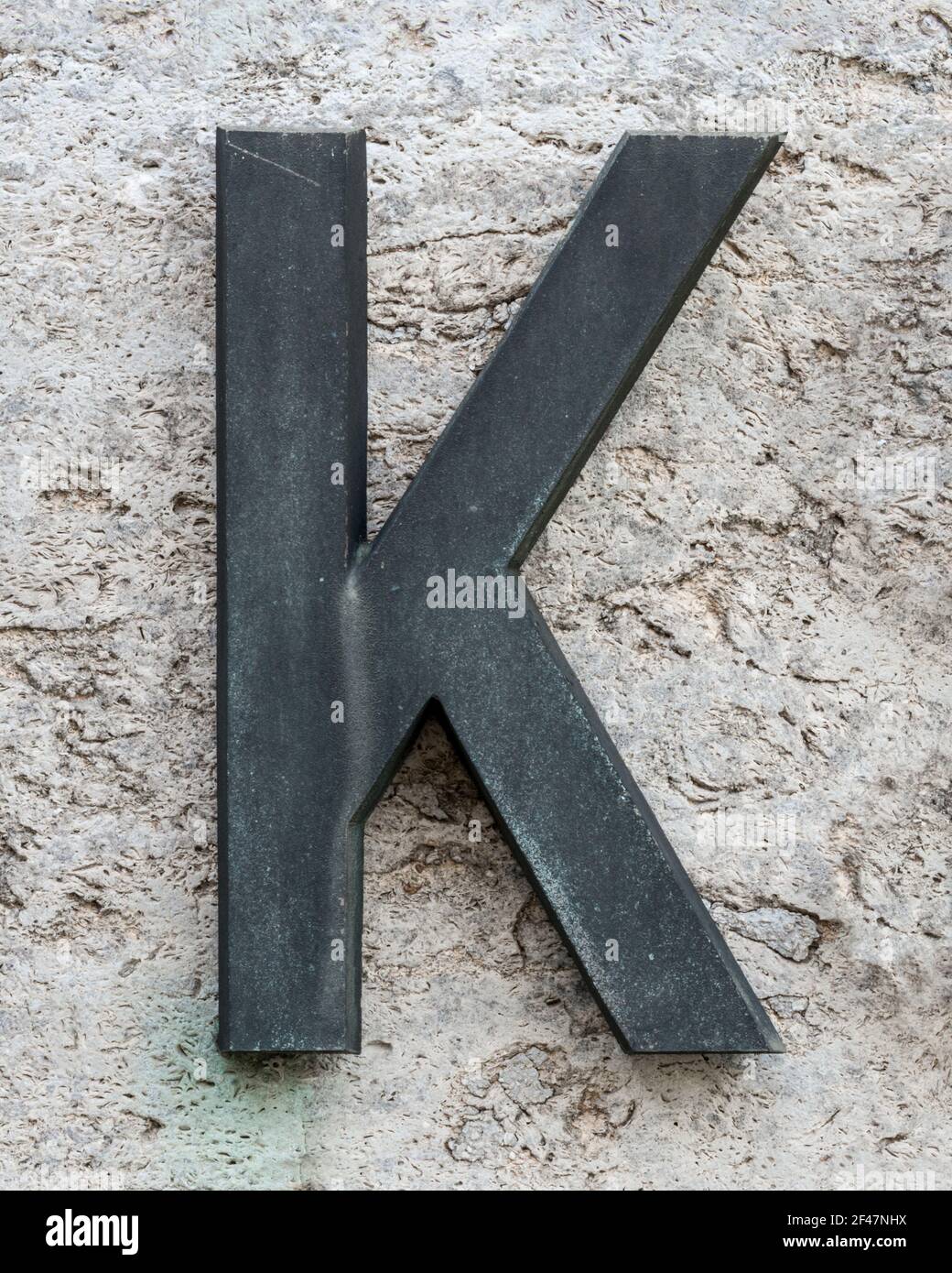 Lettre K en métal sur un mur en pierre Banque D'Images