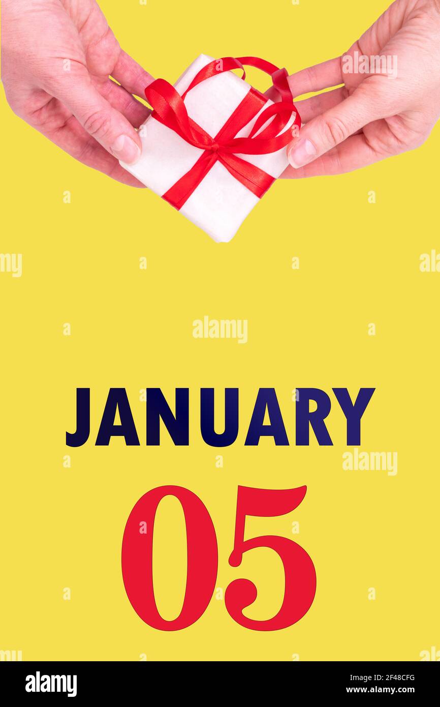 5 janvier. Calendrier vertical de fête avec mains tenant boîte cadeau blanche avec ruban rouge et calendrier Date 5 janvier sur fond jaune lumineux Photo Stock - Alamy