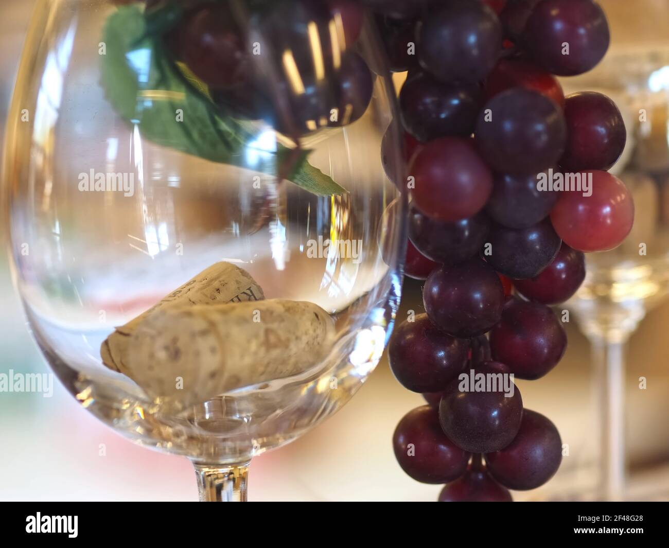 Verre avec bouchons à vin et raisins rouges Banque D'Images