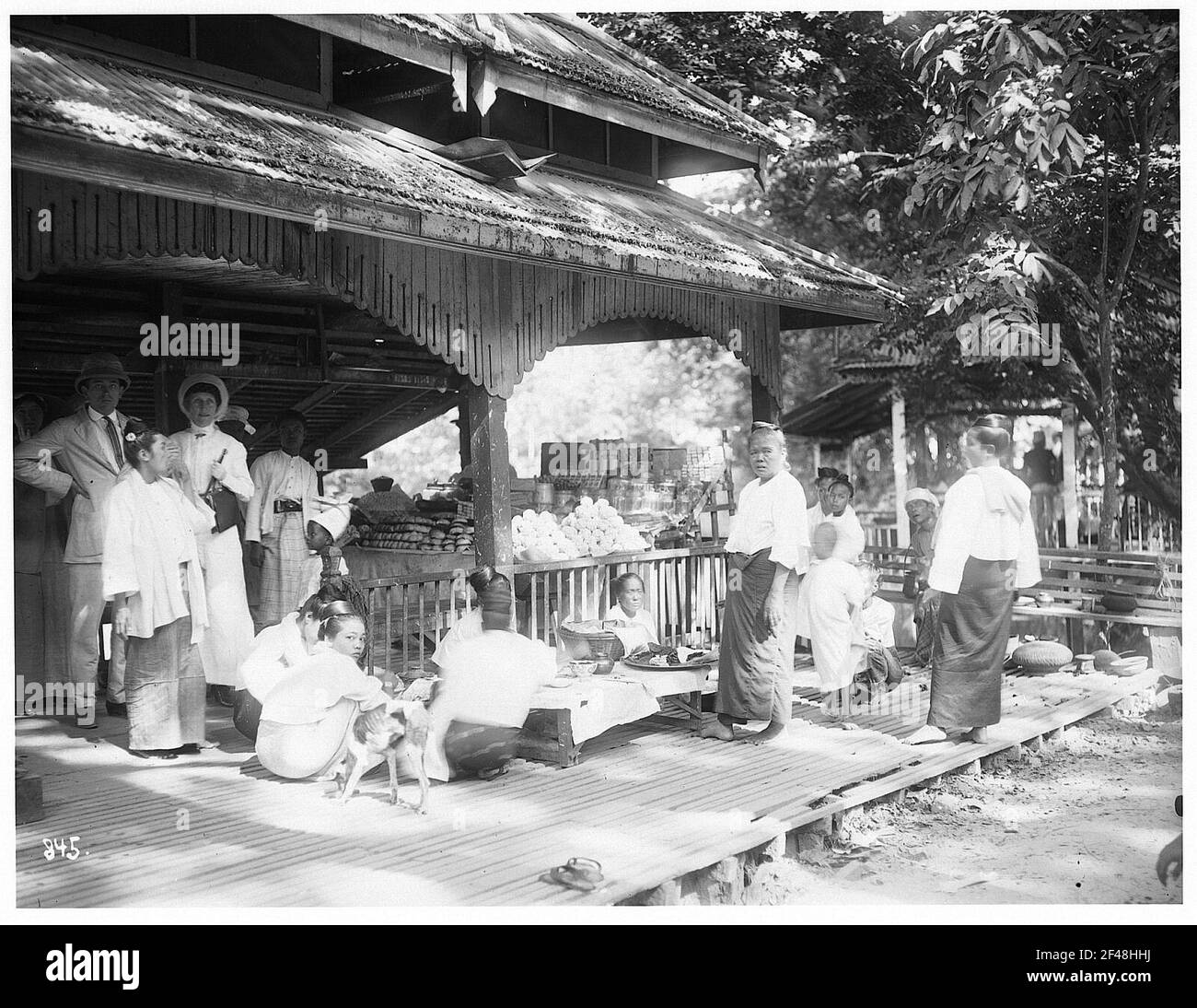 Rangonn, Birmanie. Famille Birmese avec repas, avec des touristes en arrière-plan Banque D'Images