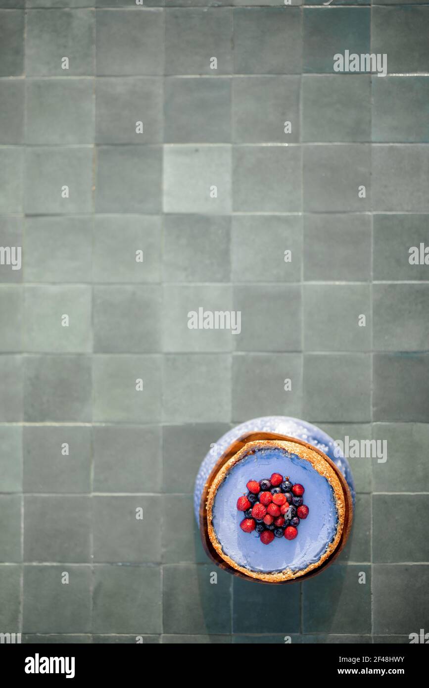 Vue de dessus sur une table carrelée de vert avec un cheesecake aux baies, composition avec un espace de copie Banque D'Images