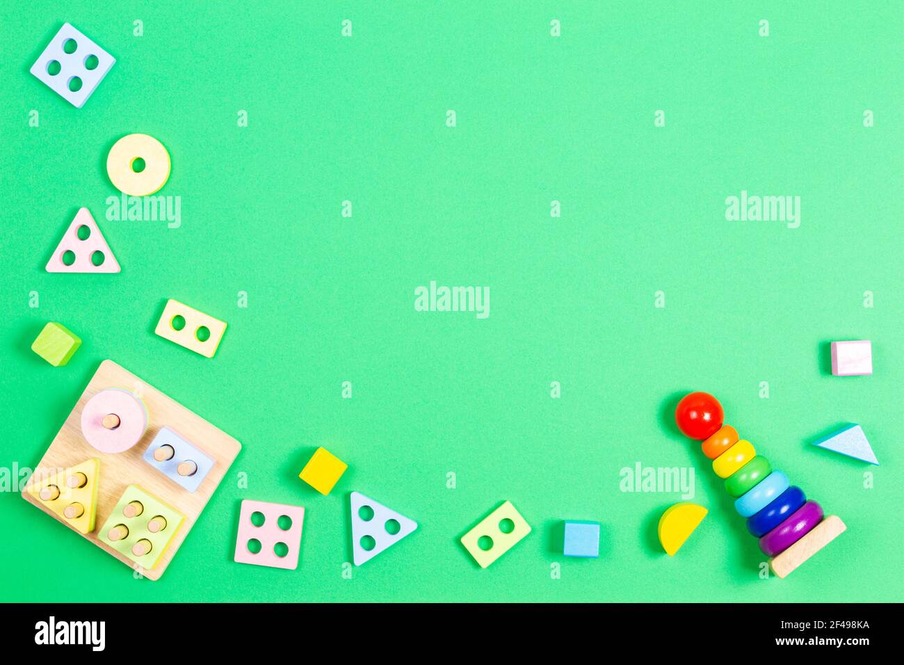 Développement de la petite enfance puzzle jouets de bébé. Jeu éducatif en bois de géométrie de couleur pastel pour les enfants sur fond vert clair. Banque D'Images