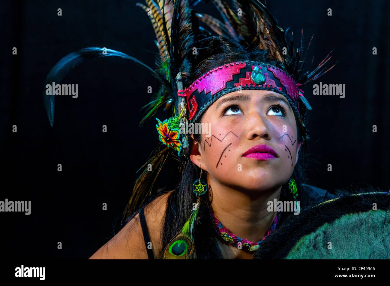 Jeune femme avec robe traditionnelle dansant avec des pièges avec des plumes et tambour Banque D'Images