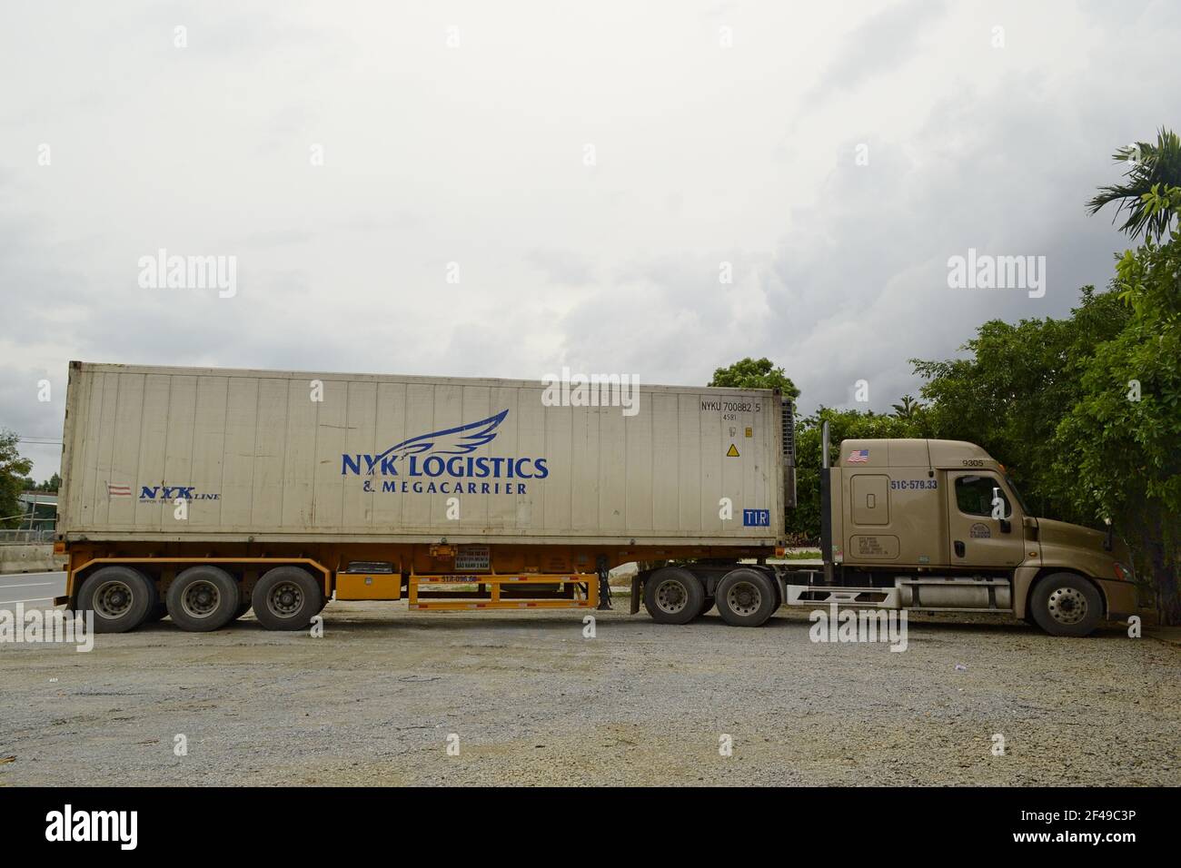 Vinh, Vietnam - septembre 2015 : un camion de transport lourd reste sur un parking près de l'autoroute. Vue latérale d'un véhicule terrestre long avec chargement Banque D'Images