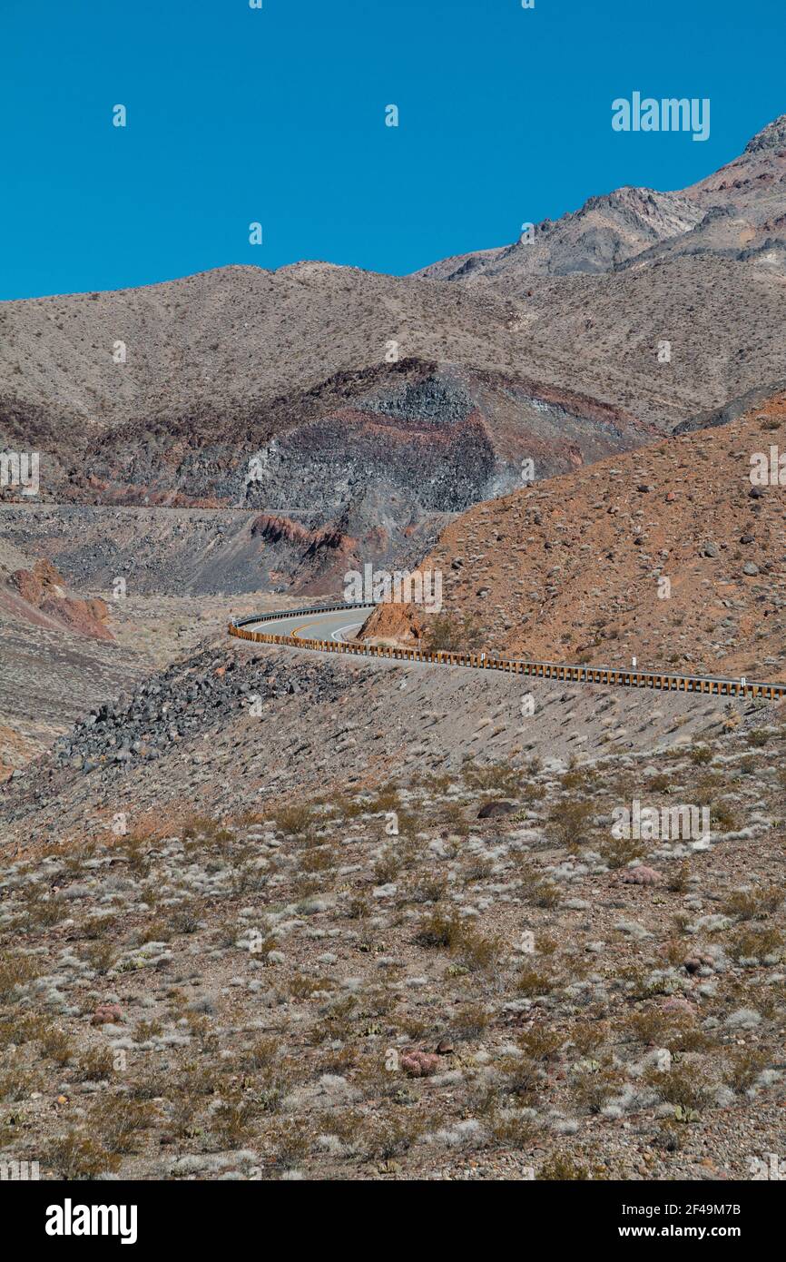Une route vide qui se courbe à travers un paysage de montagne dans la mort Vallée Banque D'Images