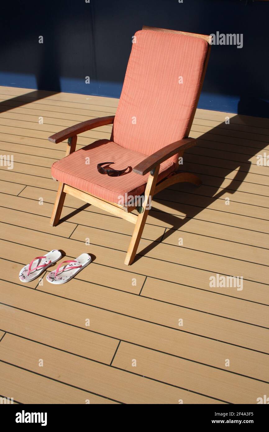 Chaise longue avec tongs sur le pont Banque D'Images