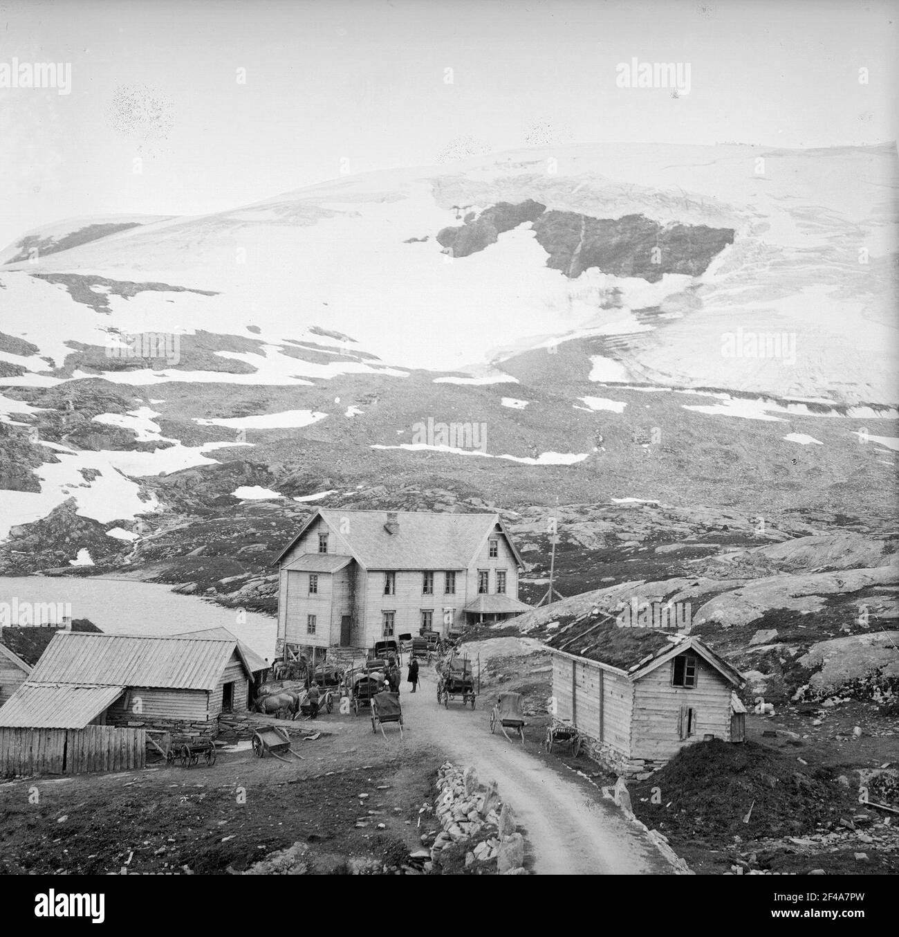 Norvège. Règlement sur le Djupwasssee. Regardez les maisons en bois sur la rive du lac au pied des montagnes enneigées Banque D'Images