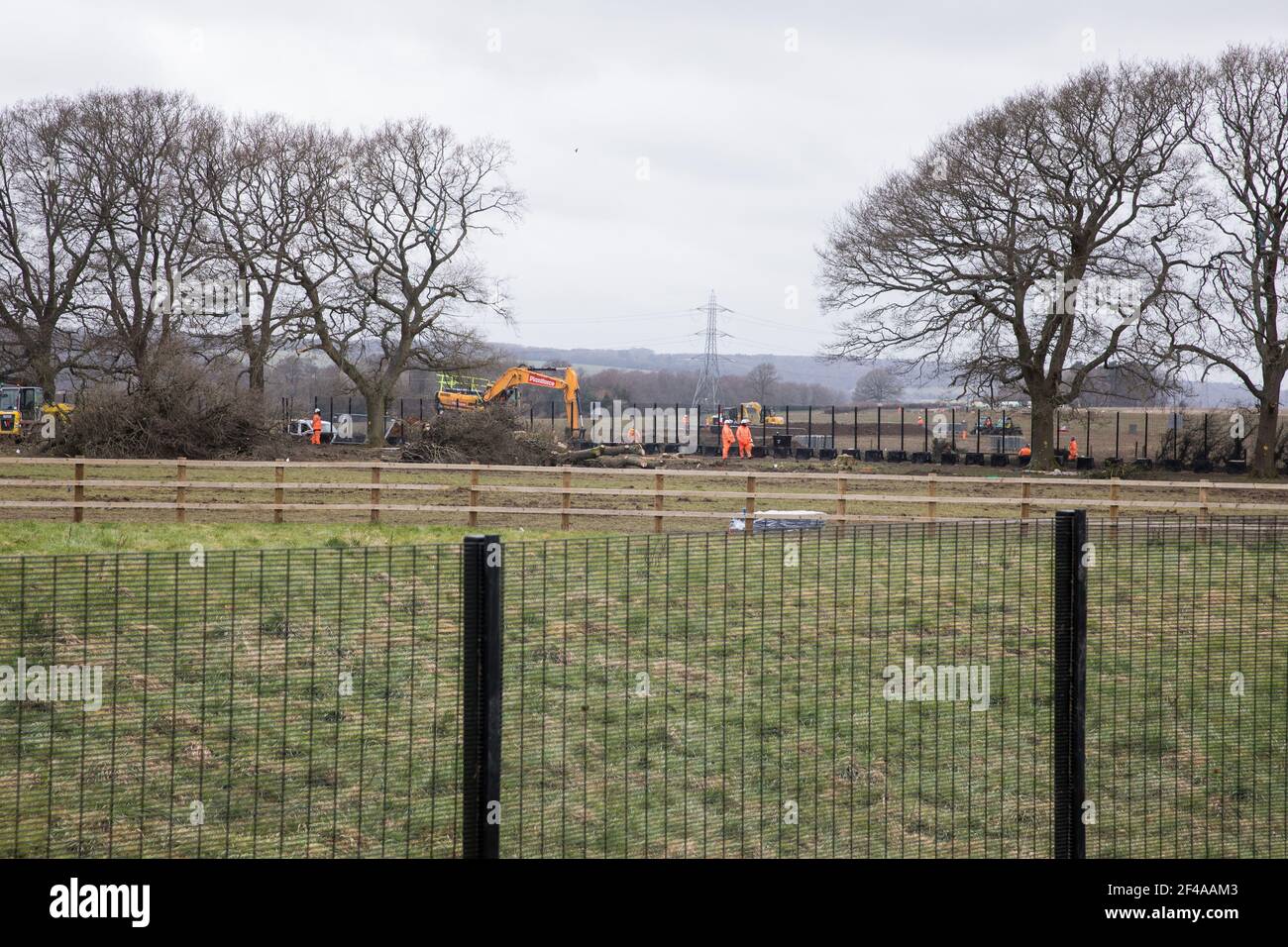 Great Missenden, Royaume-Uni. 18 mars 2021. Les entrepreneurs HS2 surveillent les travaux pour faire tomber une rangée de chênes centenaires dans Leather Lane. Près de 40,000 personnes ont récemment signé une pétition demandant que les chênes qui bordent l'ancienne voie de campagne ne soient pas abattus pour faire place à une route de transport temporaire et à un complexe de construction. Les résidents et les agents de protection de la nature locaux ont accusé les entrepreneurs HS2 de détruire des boîtes à oiseaux actives sur le site. Crédit : Mark Kerrison/Alamy Live News Banque D'Images