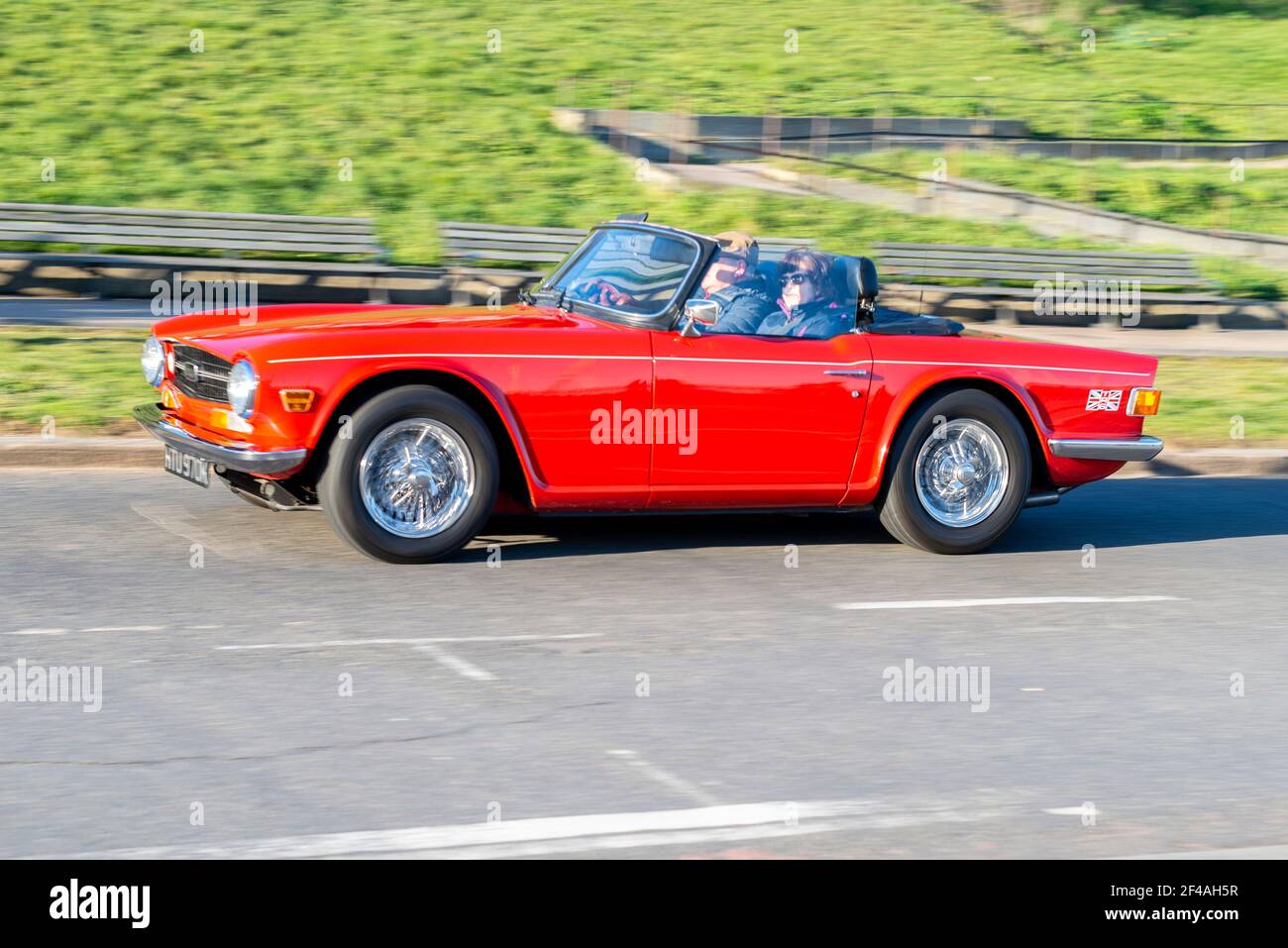 Triemumph TR6 voiture classique conduite à Southend on Sea, Essex, Royaume-Uni. Voiture de sport rouge décapotable vintage avec la capote vers le bas lors d'une journée ensoleillée Banque D'Images