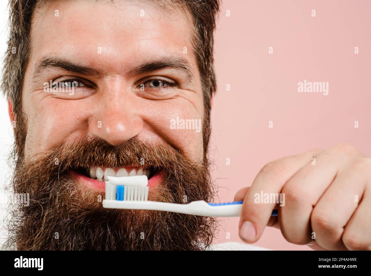 Homme barbu souriant se brossant les dents. Pâte à dents. Brosse à dents. Hygiène dentaire. Soins buccaux. Gros plan. Banque D'Images