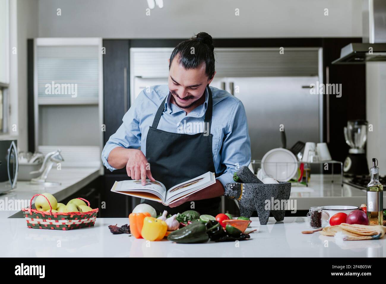 latino-homme cuisant à la maison de la salade ou de la sauce mexicaine Dans la cuisine à la maison dans la ville de Mexico Banque D'Images