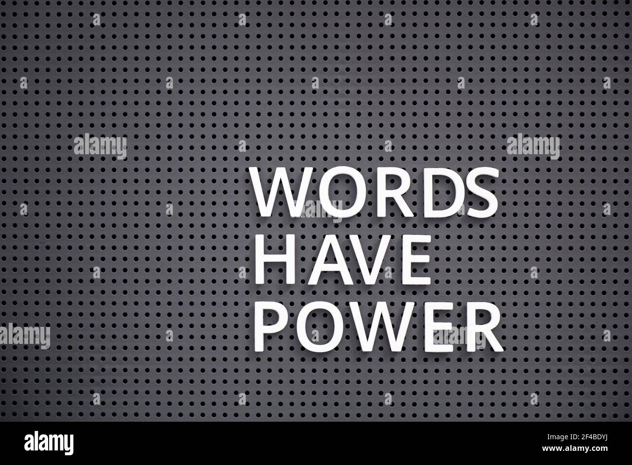 Les mots de phrase ont la puissance orthographiée avec des lettres blanches sur panneau perforé gris Banque D'Images