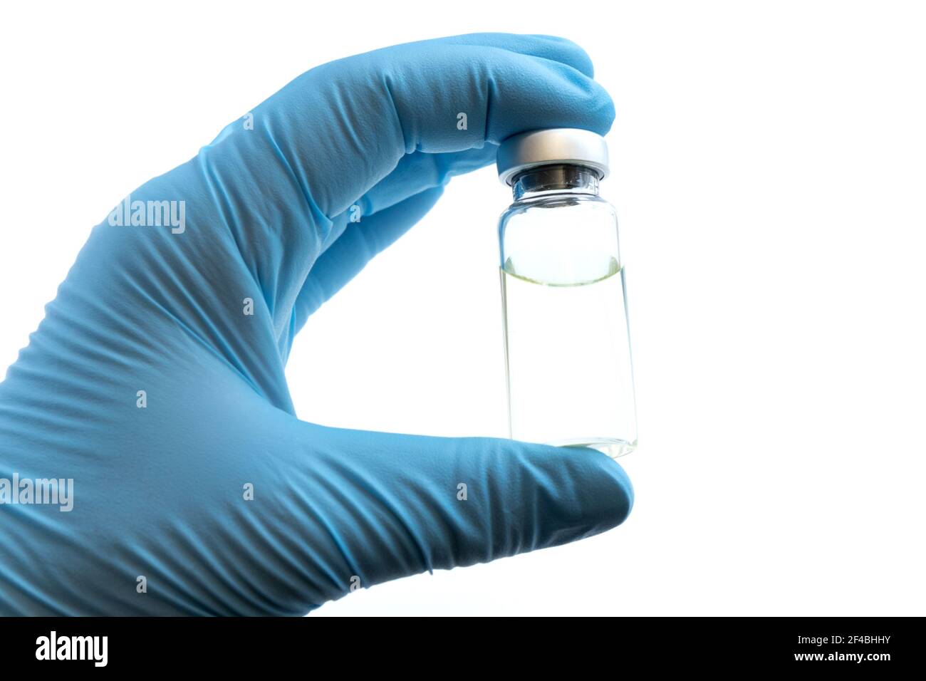 Main du médecin en gants bleus tenir le flacon avec un vaccin ou un médicament sur fond blanc. Concept d'étude de vaccination contre le coronavirus. Banque D'Images